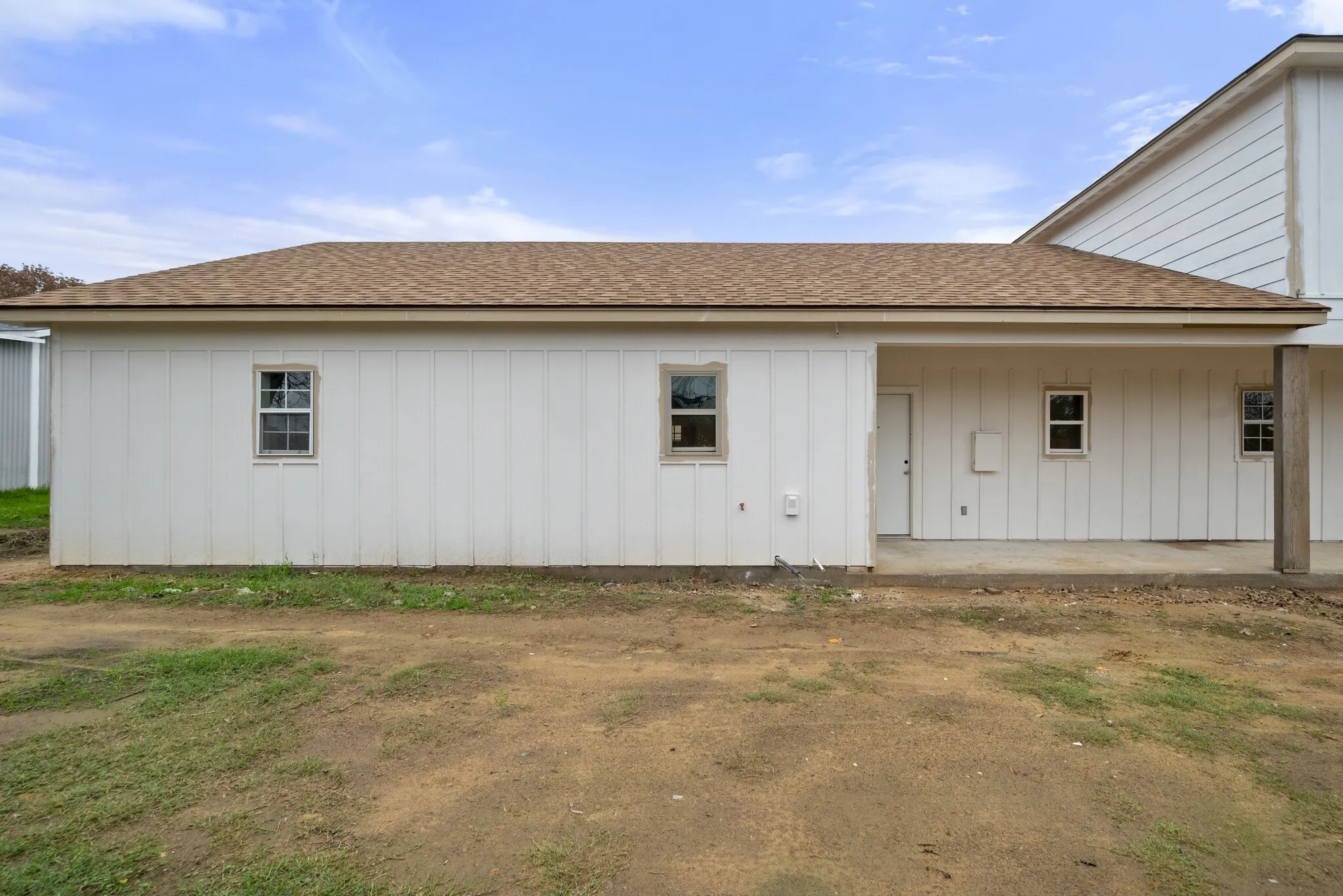 Back of house with roof with shingles and board and batten siding