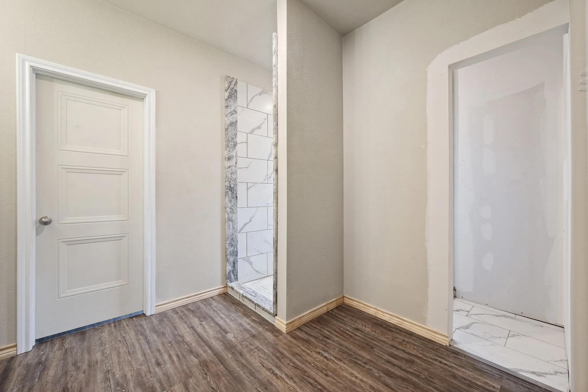 Full bath with a tile shower and wood finished floors