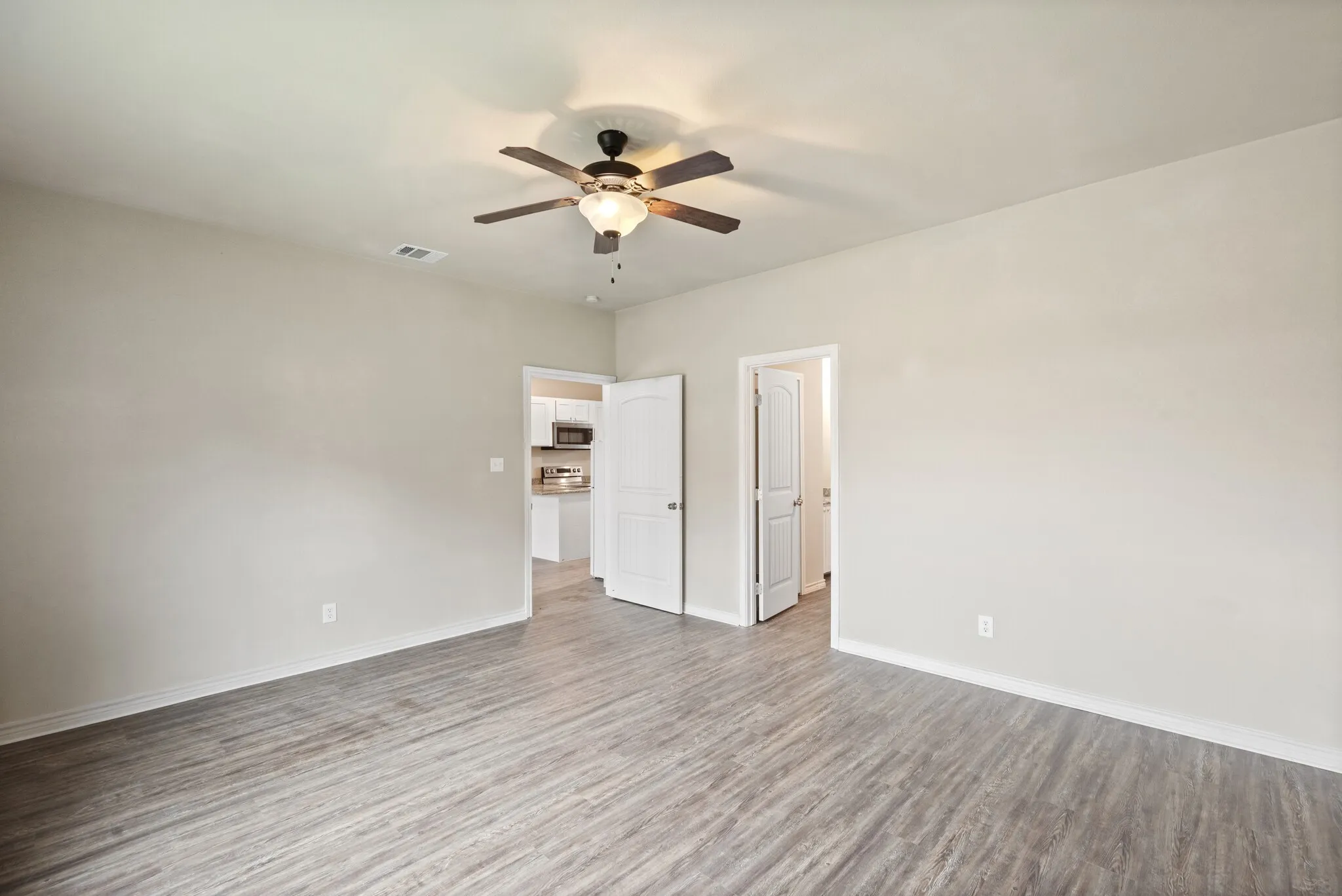 Unfurnished bedroom with ceiling fan and light wood-style floors