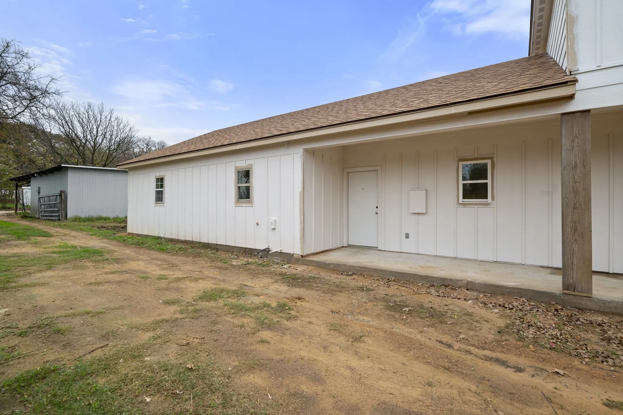 Back of property featuring a shingled roof, a patio, and board and batten siding