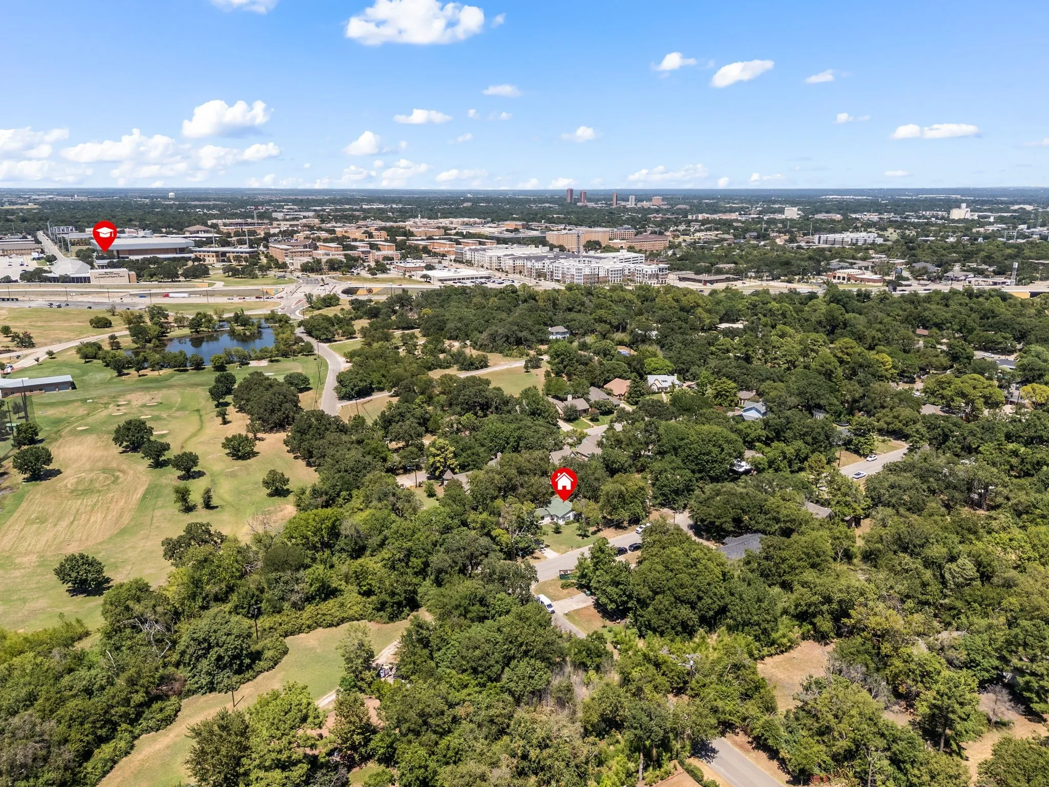 Drone / aerial view of a nearby body of water and a golf course