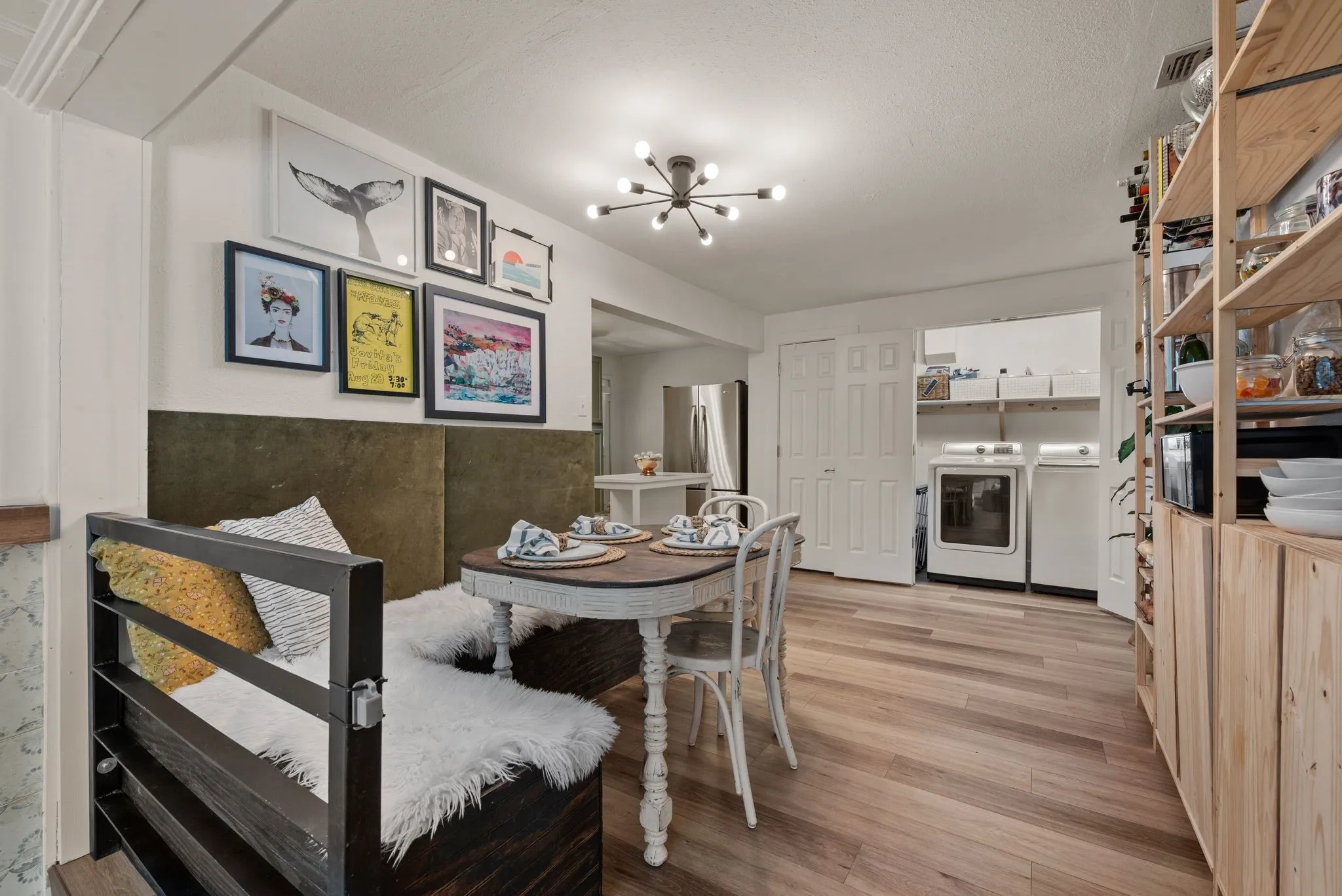 Dining area with independent washer and dryer, a chandelier, and light wood-style flooring