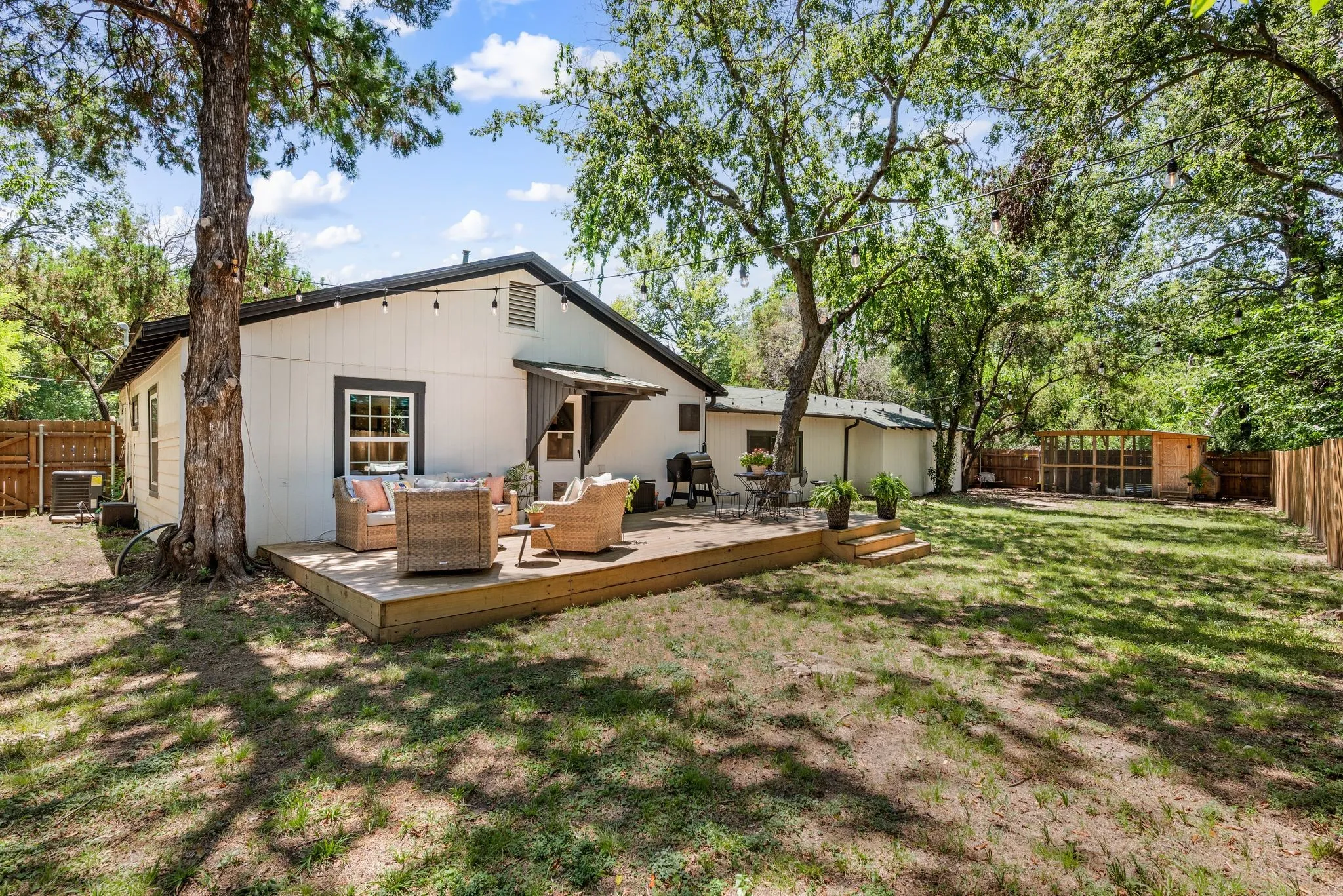 Rear view of house with a fenced backyard, a wooden deck, and outdoor lounge area