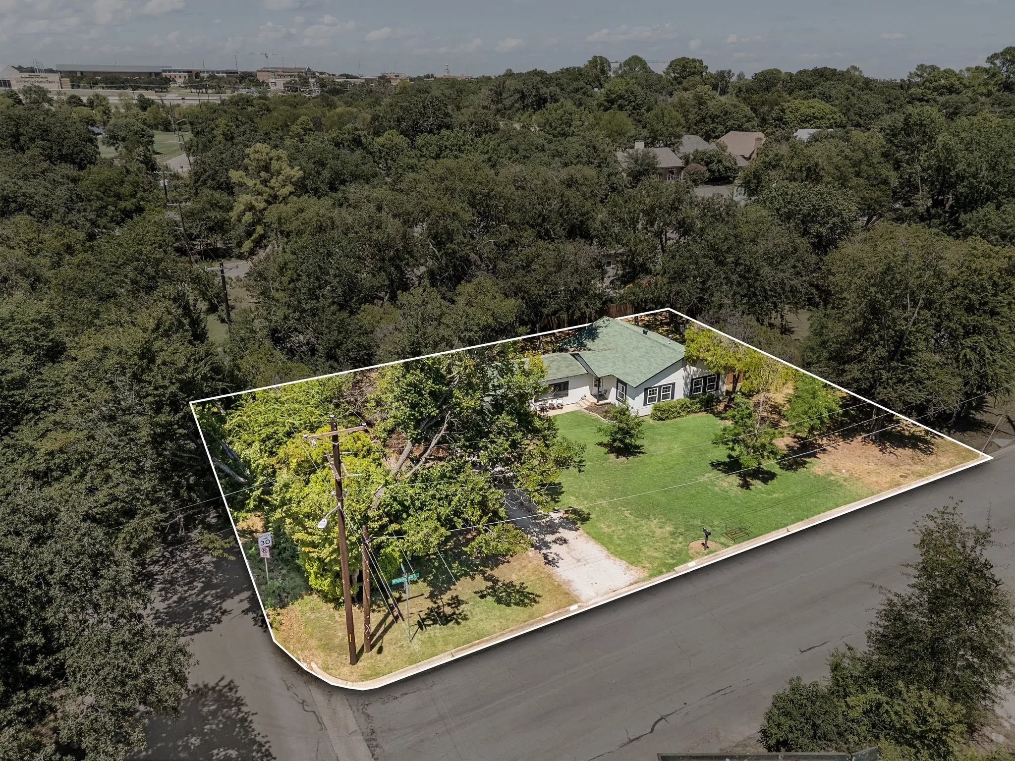 Aerial view of property and surrounding area with property boundaries highlighted and a forest