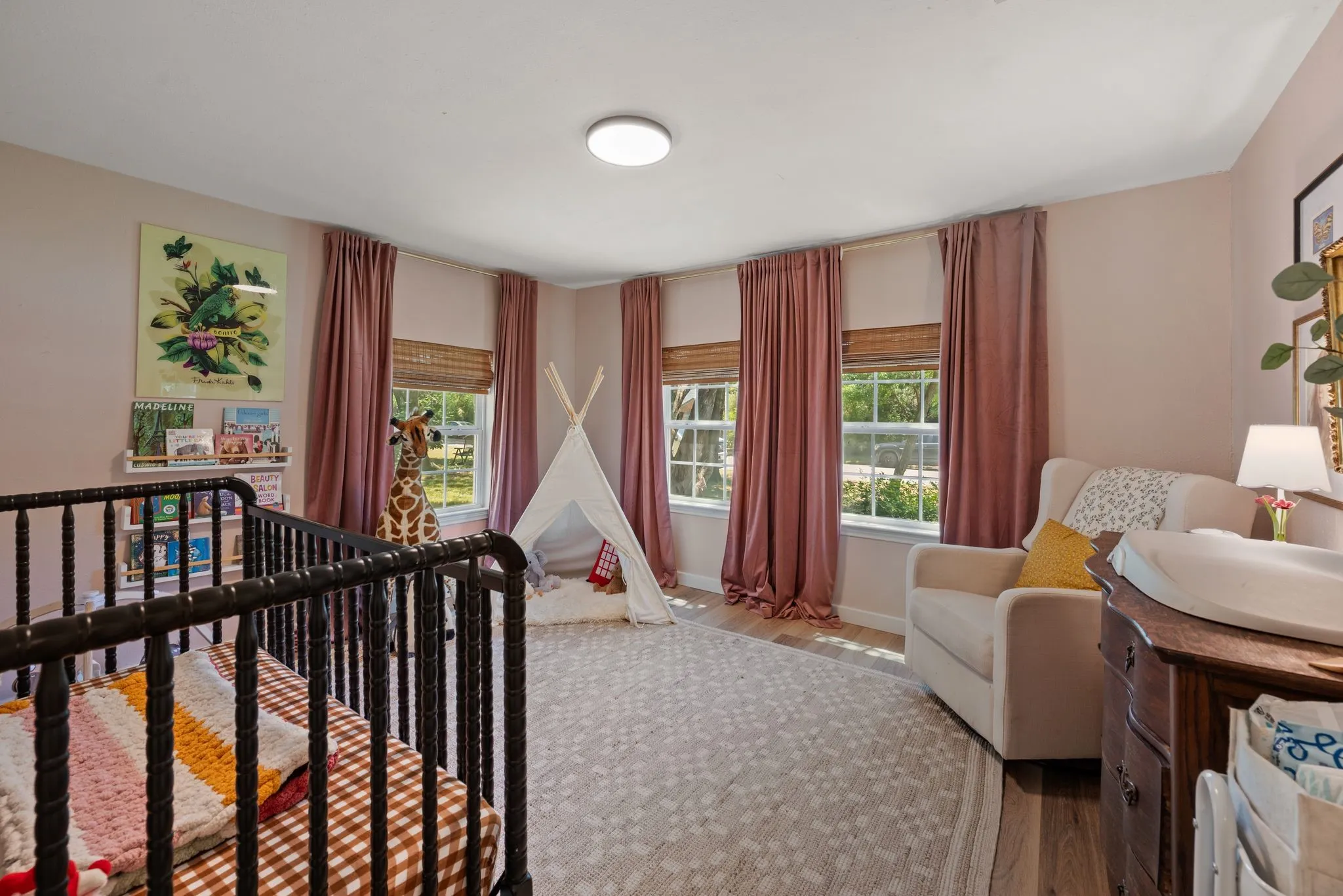 Bedroom with wood finished floors and multiple windows