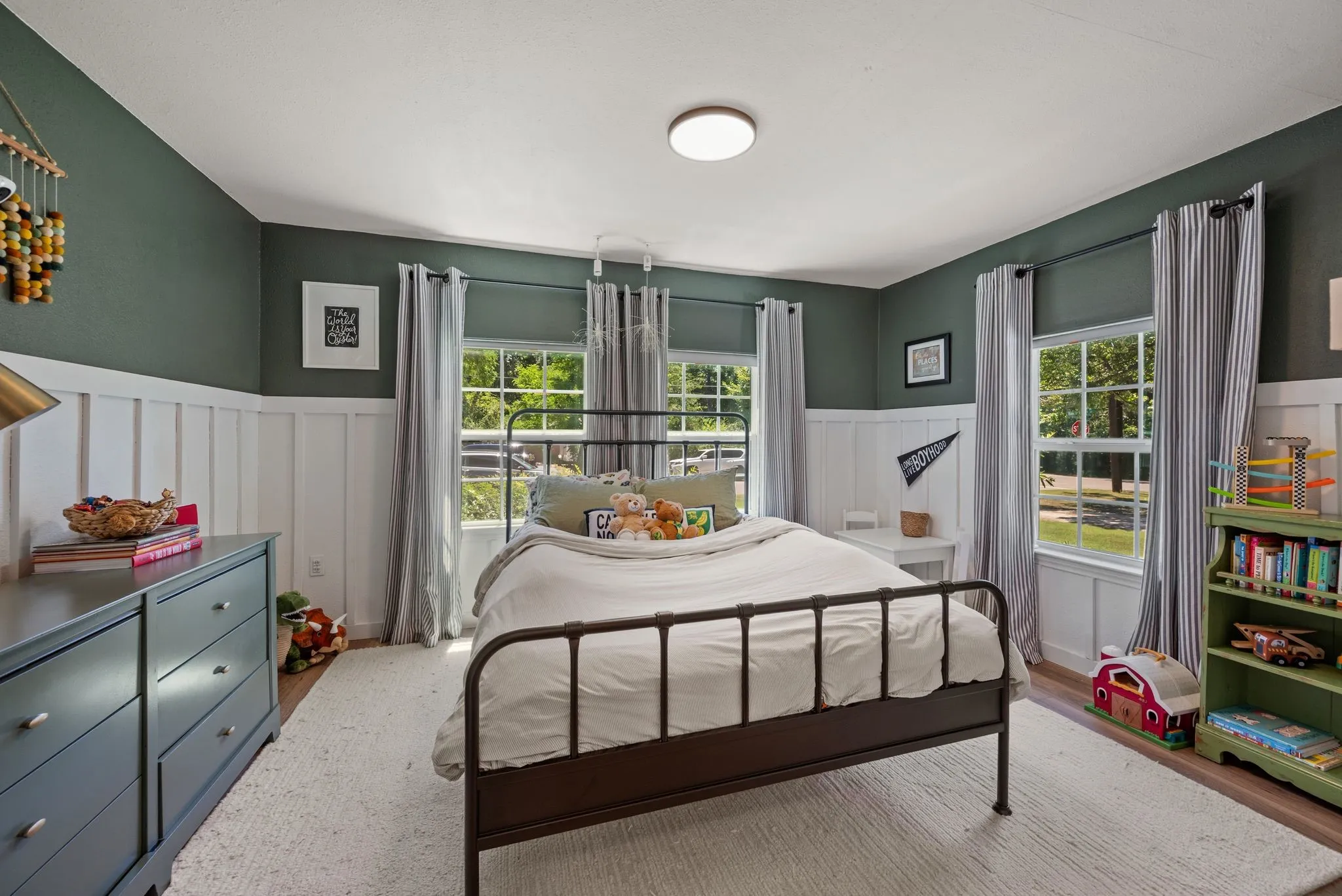 Bedroom with a wainscoted wall and wood finished floors