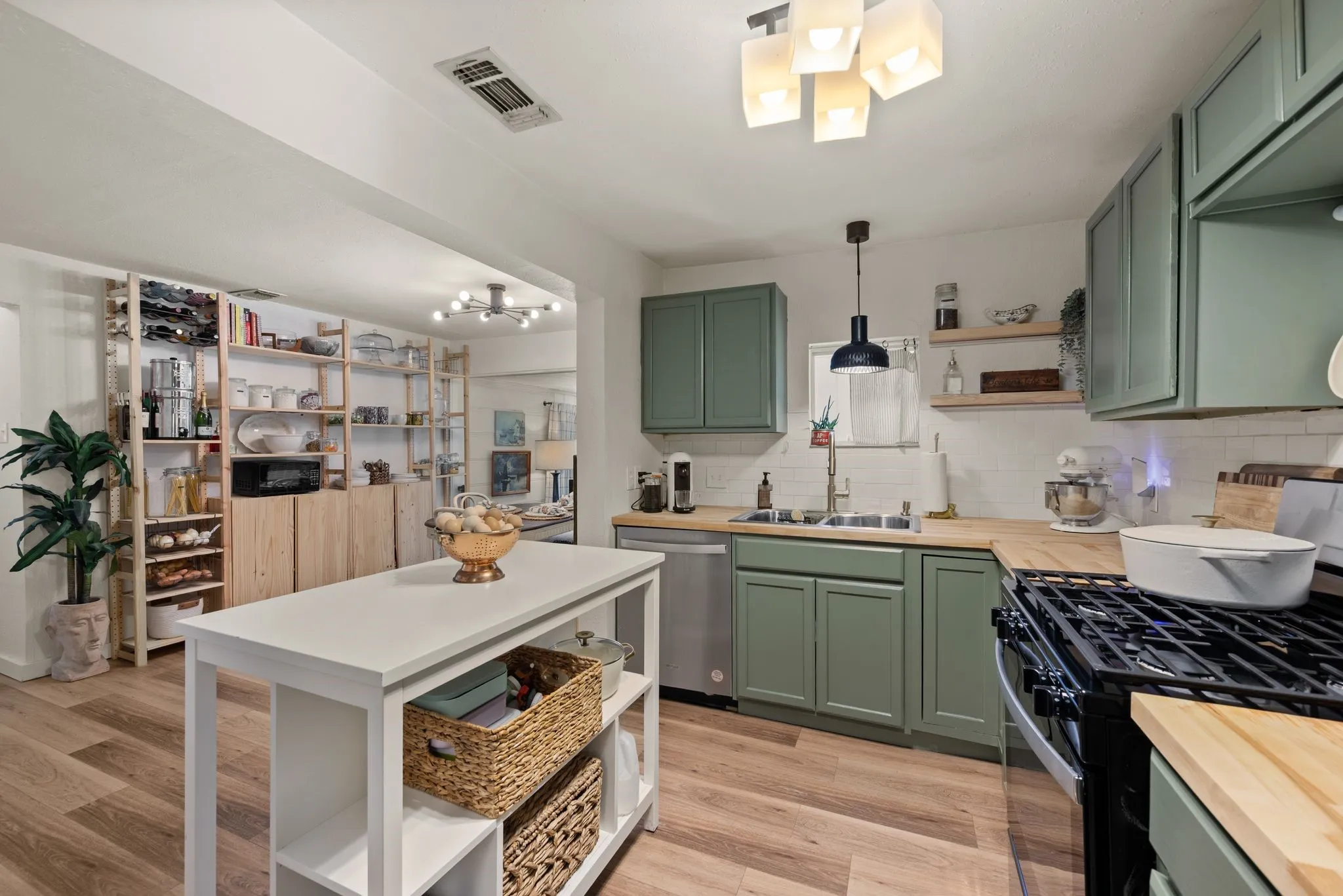 Kitchen featuring green cabinetry, open shelves, and butcher block countertops