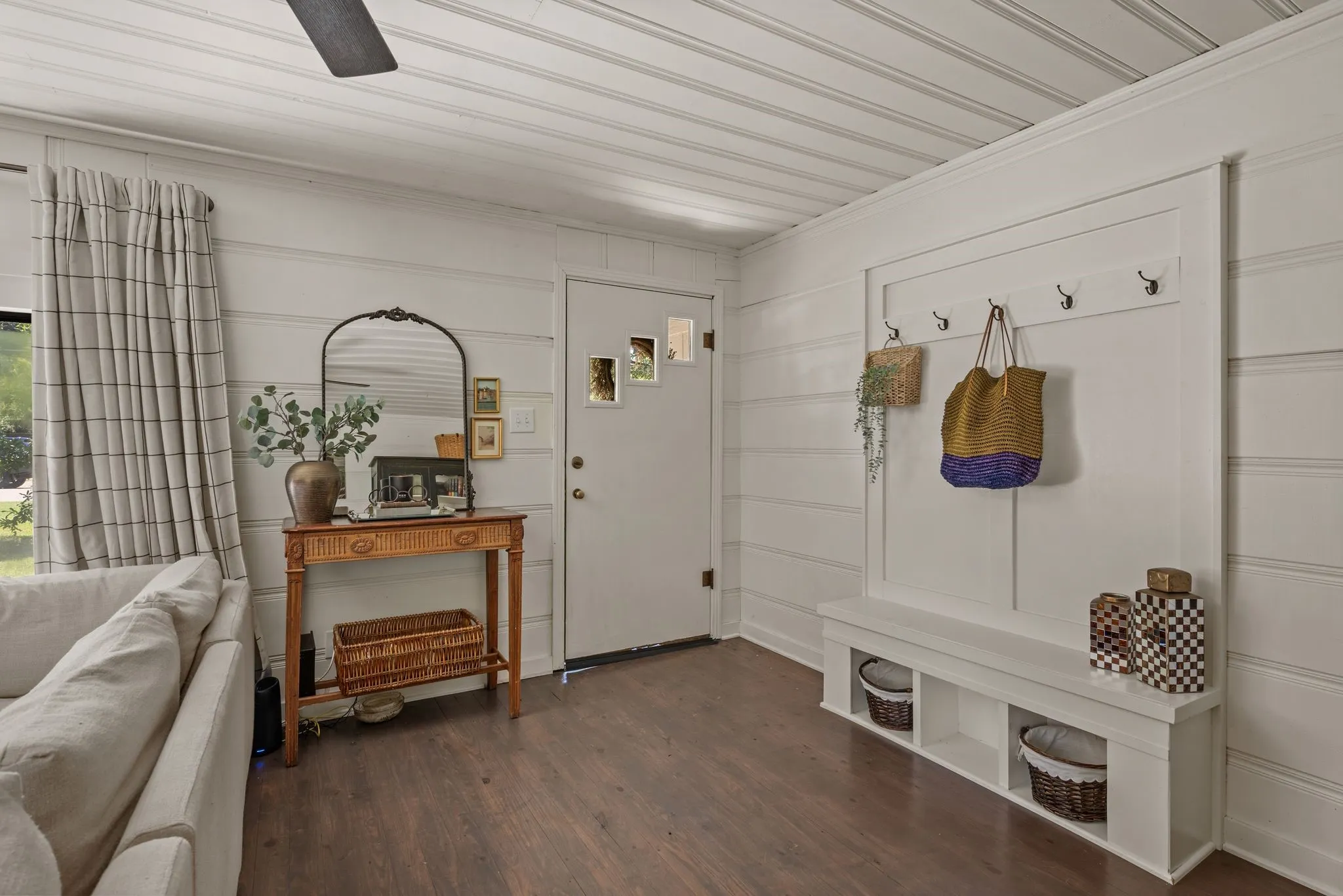 Mudroom with wood finished floors and a decorative wall