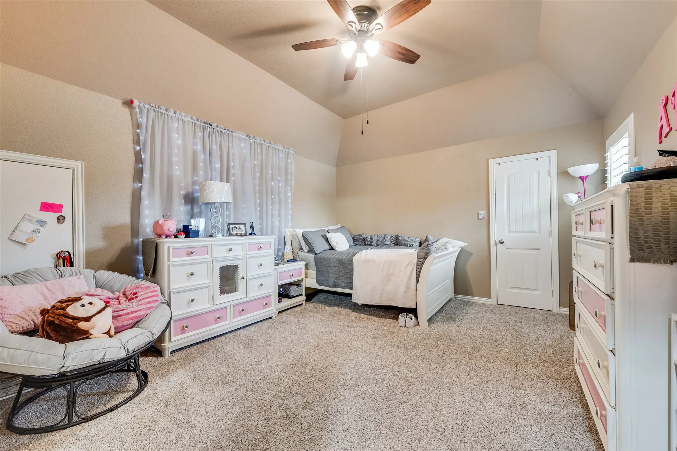Bedroom with vaulted ceiling, light colored carpet, and a ceiling fan