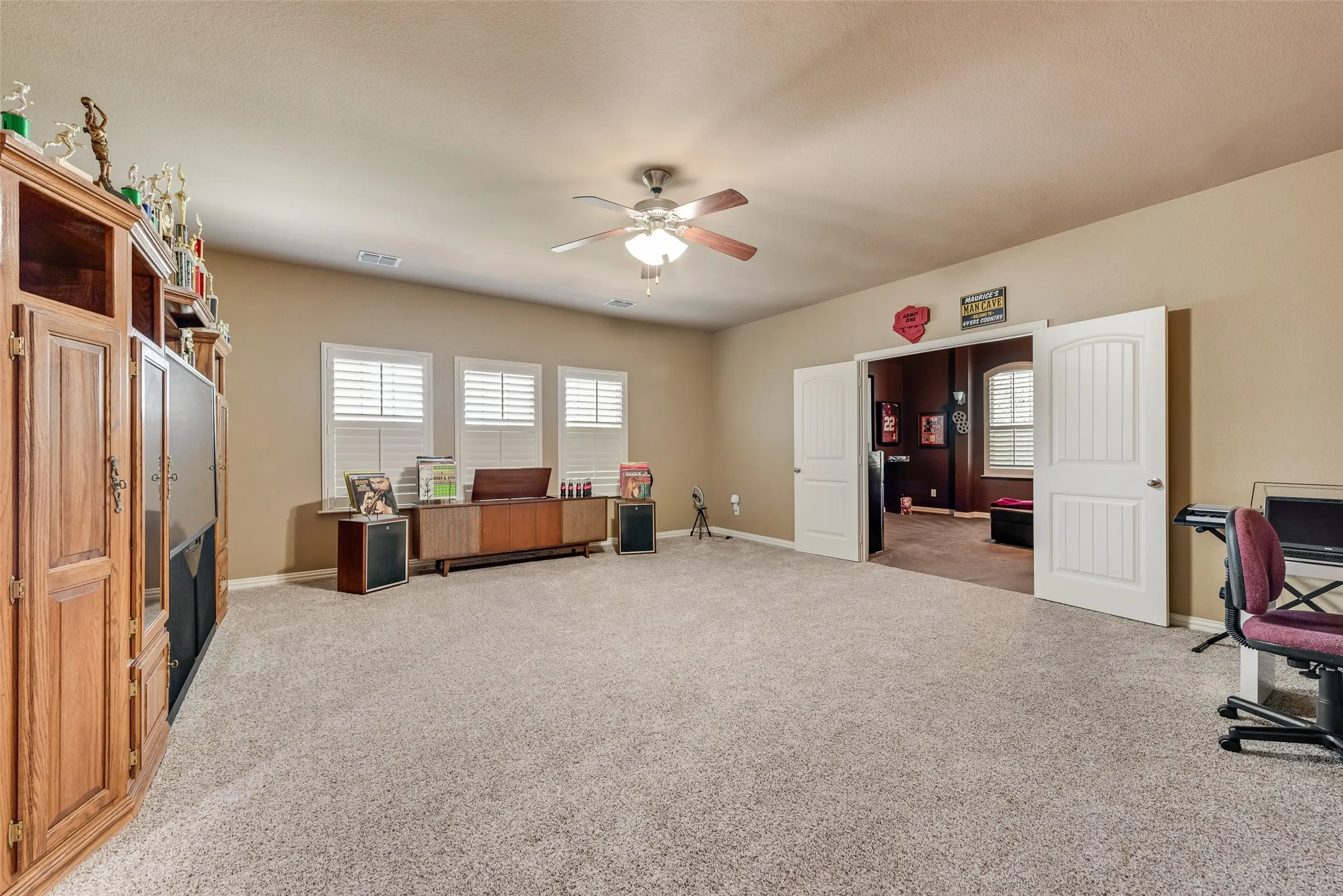 Home office featuring light carpet and a ceiling fan
