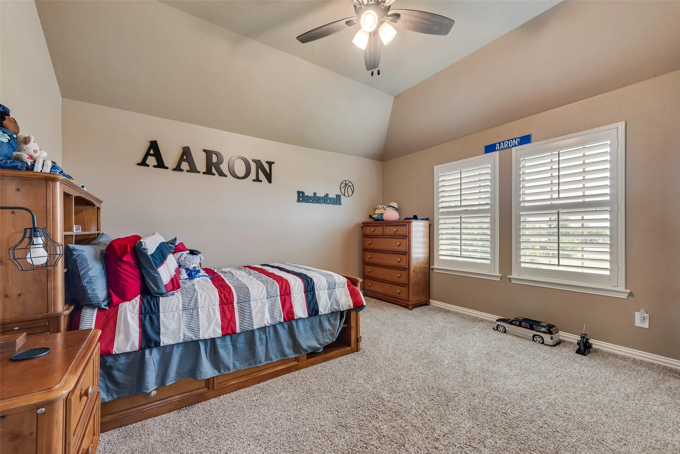 Bedroom with lofted ceiling, light carpet, and ceiling fan