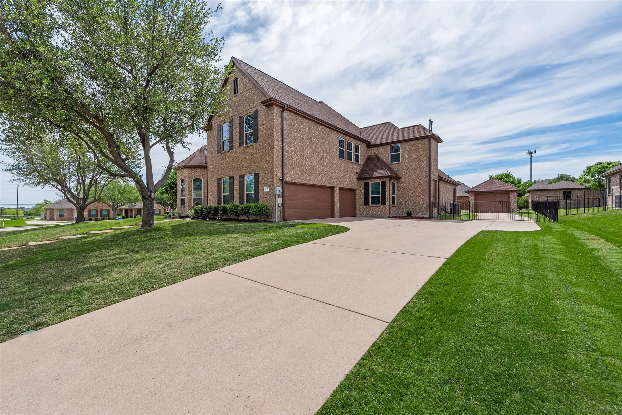 View of front facade featuring brick siding, an attached garage, and driveway