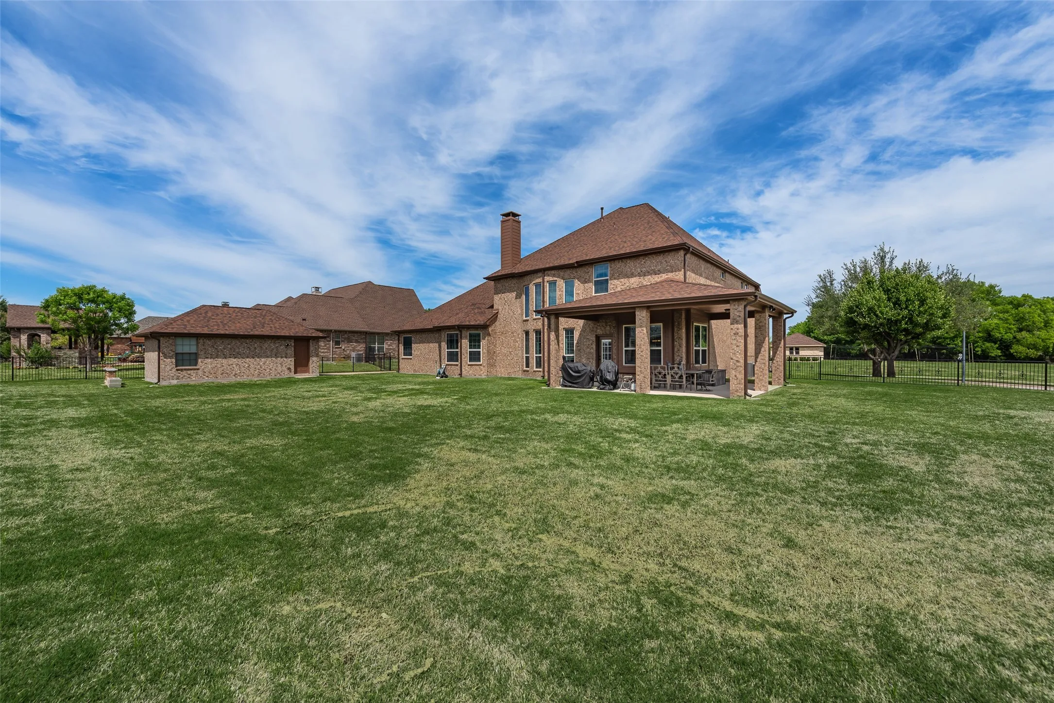 Rear view of house with a patio, brick siding, and a chimney