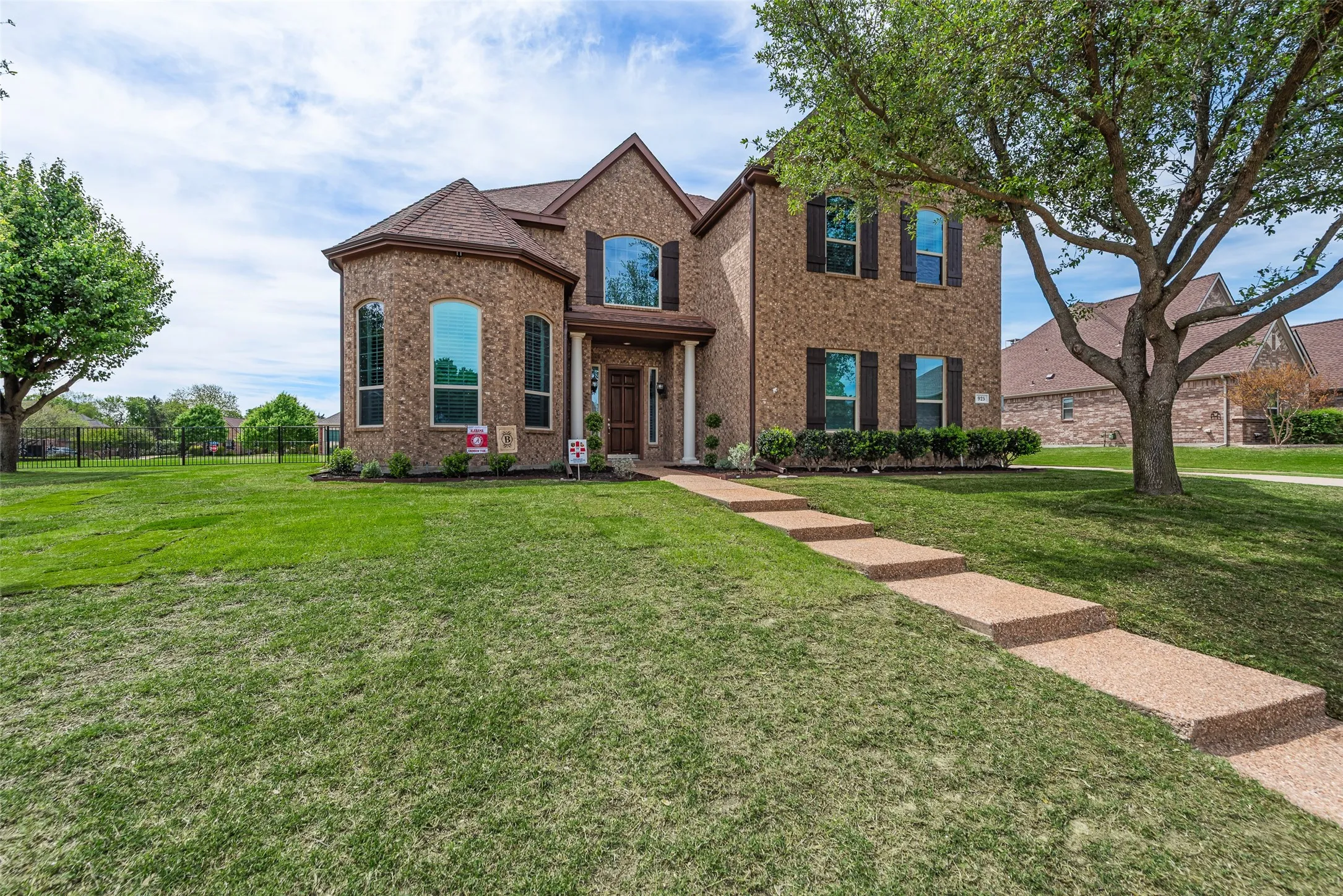 French country inspired facade with a front lawn and brick siding