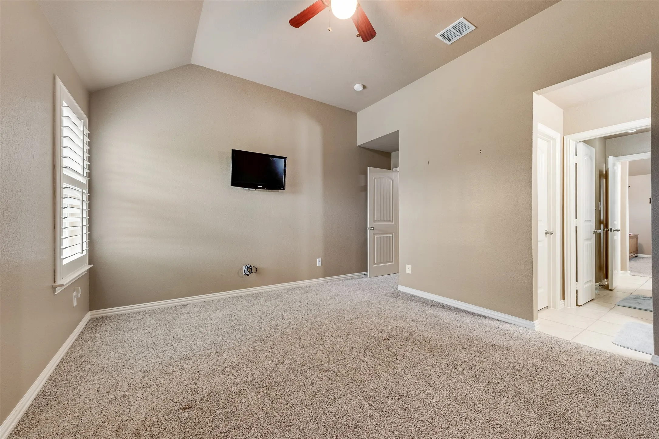 Spare room featuring light carpet and a ceiling fan
