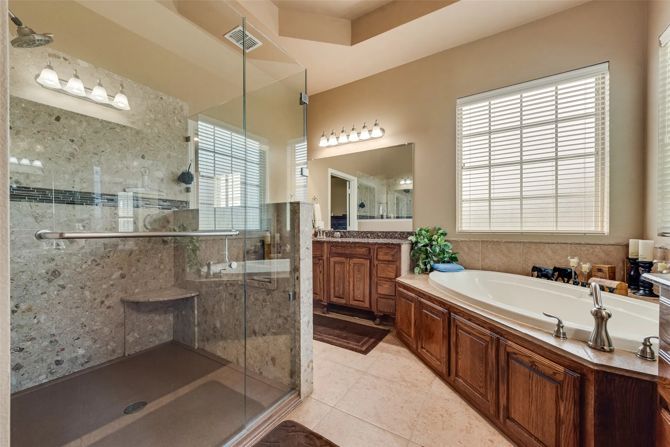 Full bathroom featuring vanity, a bath, a shower stall, and light tile patterned floors