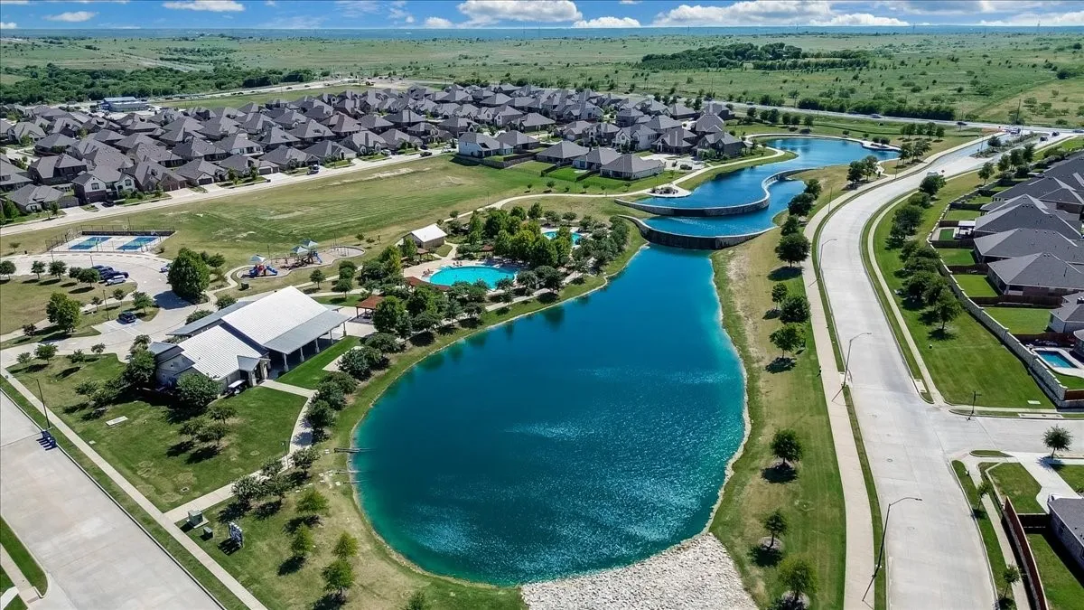 Community featuring a large recreational building, multiple lakes, a playground, and a swimming pool