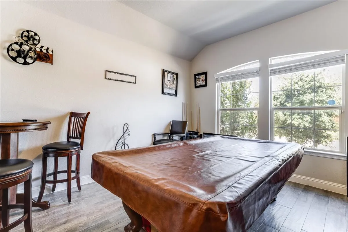 Vaulted ceiling, arched windows, wood-finish flooring, white wall paint