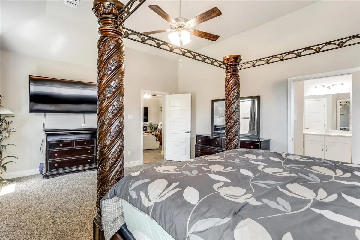 Carpeted bedroom with a ceiling fan, light gray painted walls, and a white paneled door