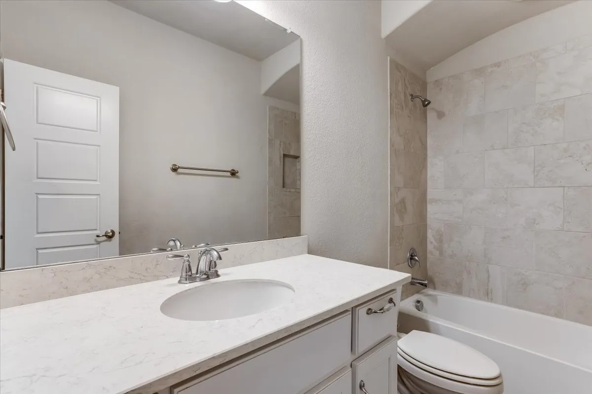 White vanity with dual cabinet doors and drawers, light-colored countertop, integrated sink, and chrome faucet