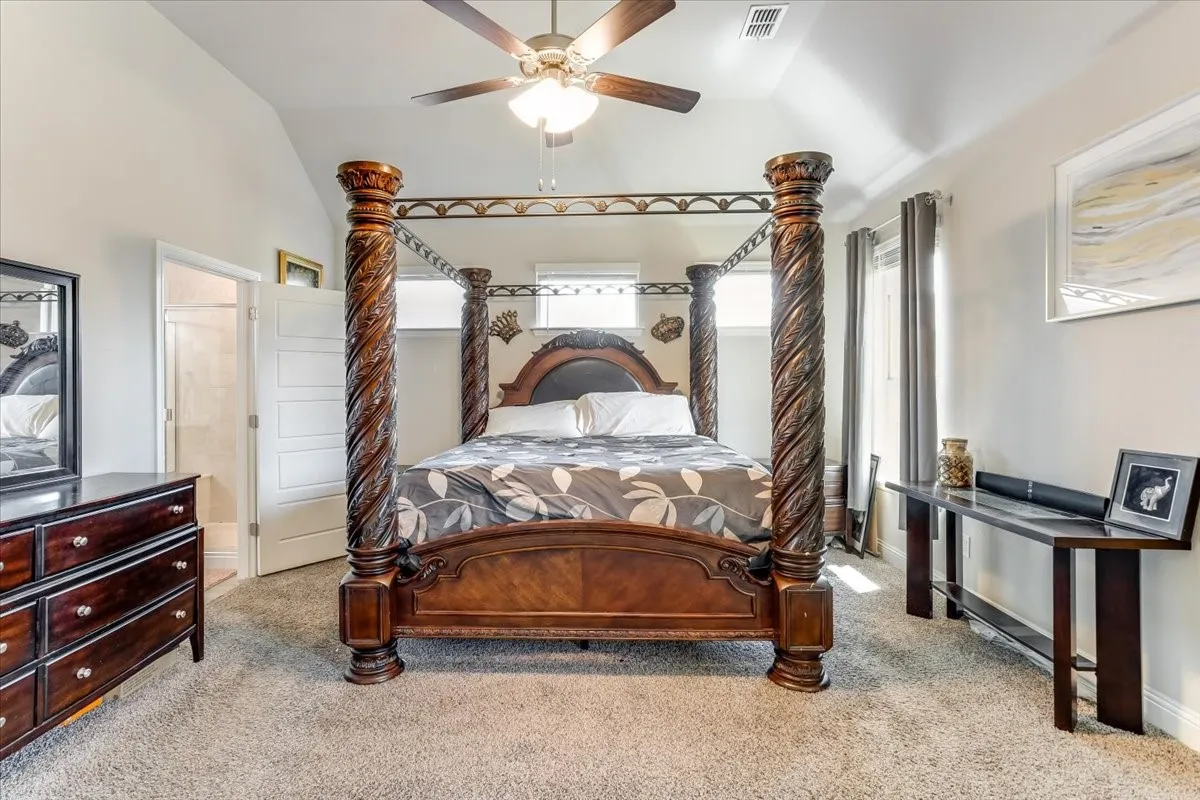 Vaulted ceiling, ceiling fan, carpeted flooring, and a window with blinds