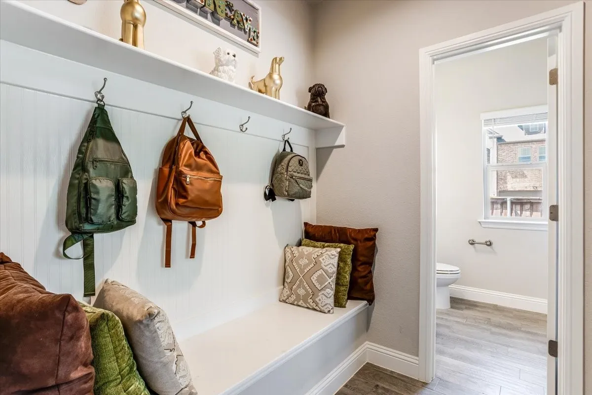 Built-in bench with storage, wall-mounted hooks, and a display shelf