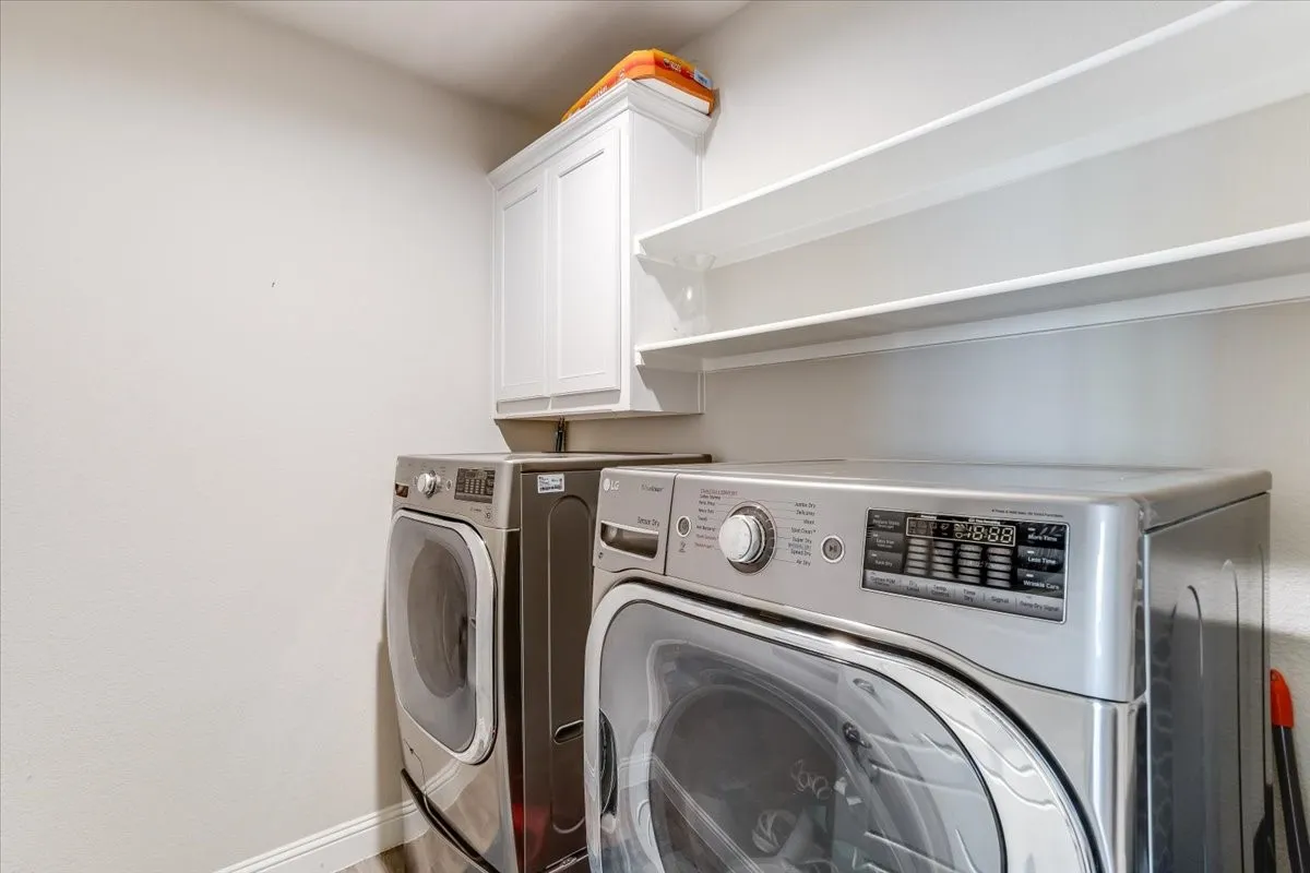 White cabinetry with upper shelving and wood-finish flooring
