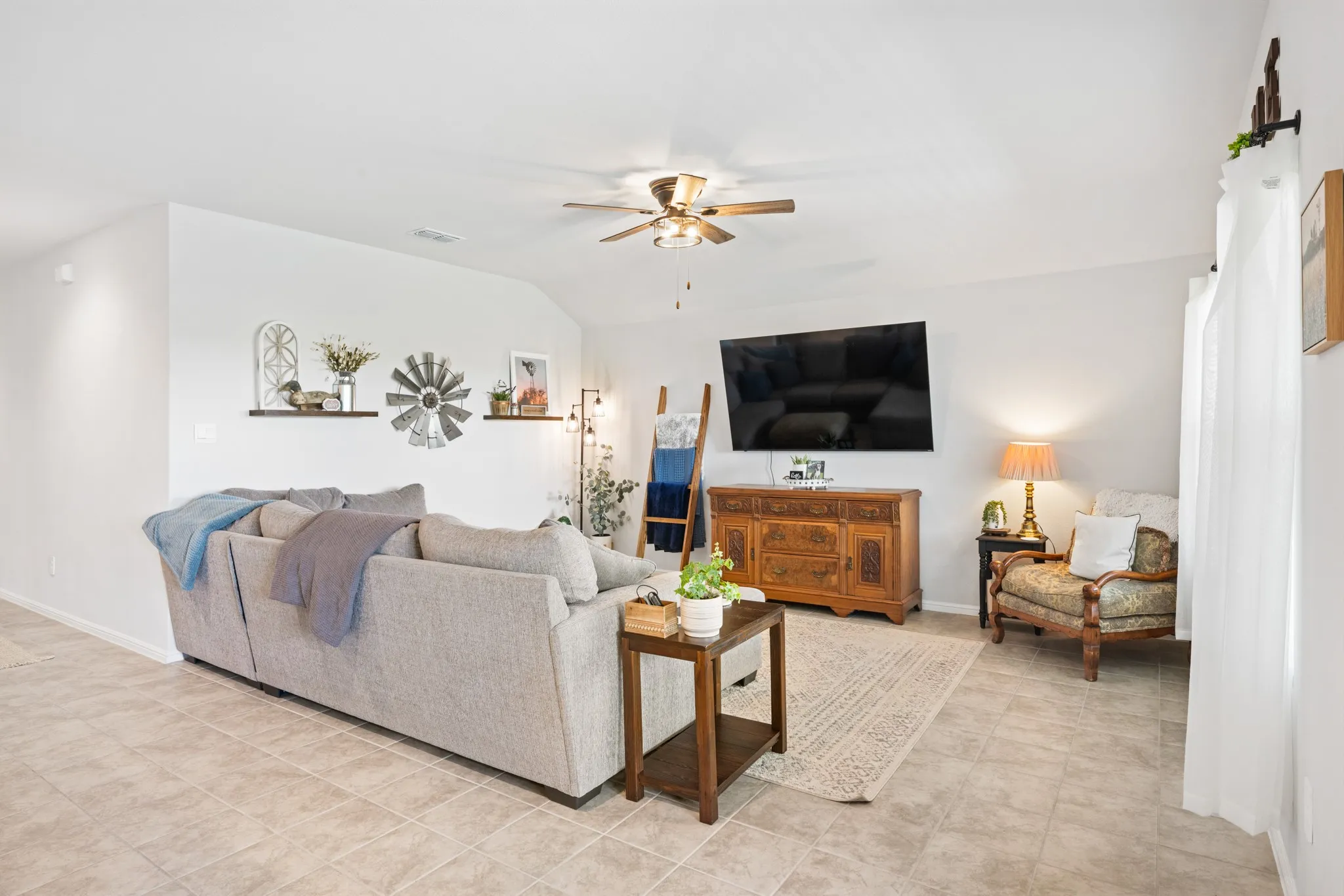 Living room with a ceiling fan and vaulted ceiling