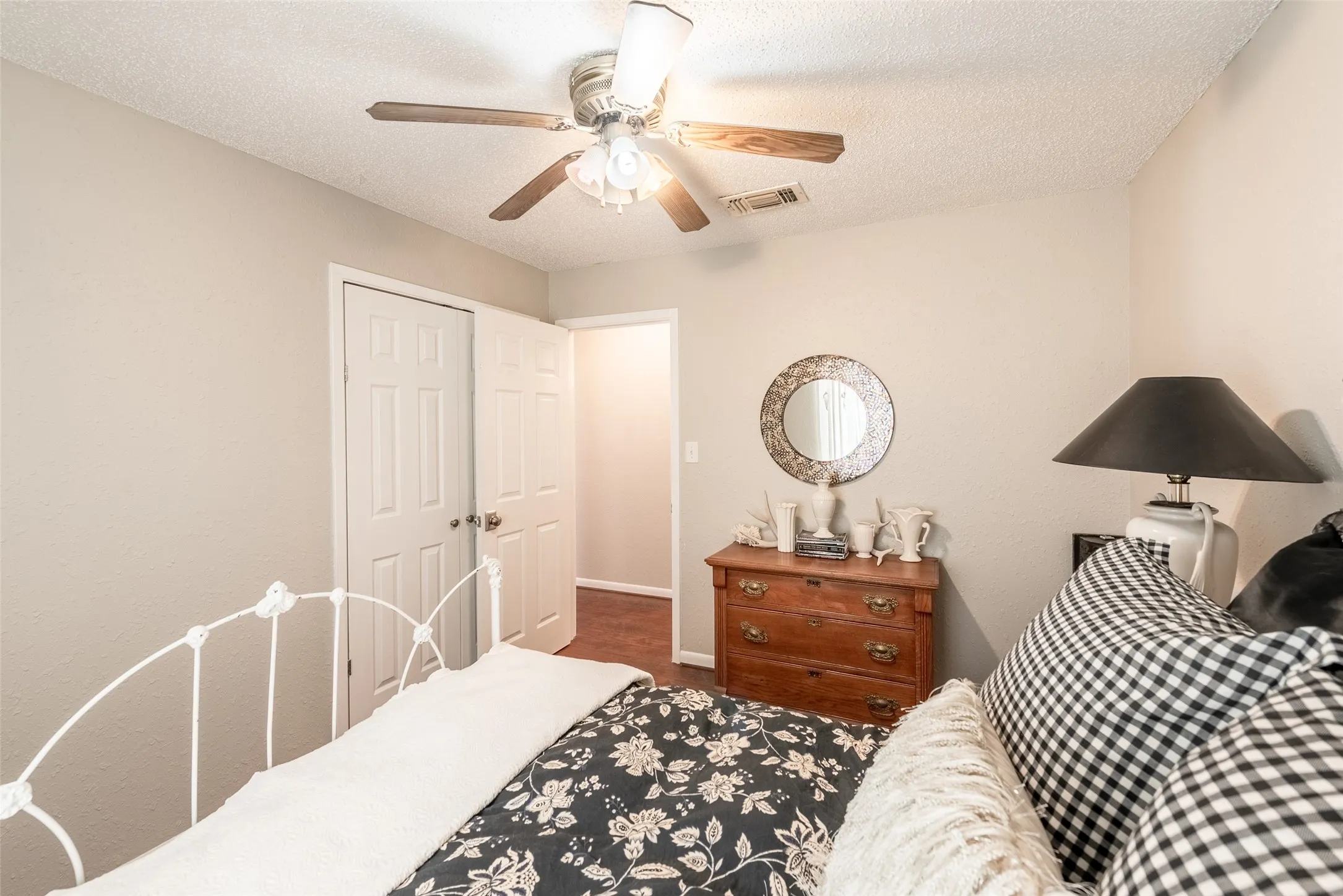 Bedroom with a textured ceiling, a closet, and ceiling fan