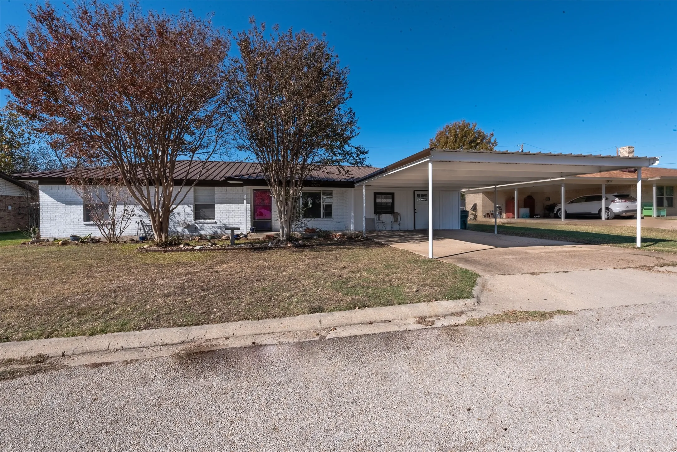 View of front of house with a carport and a front lawn