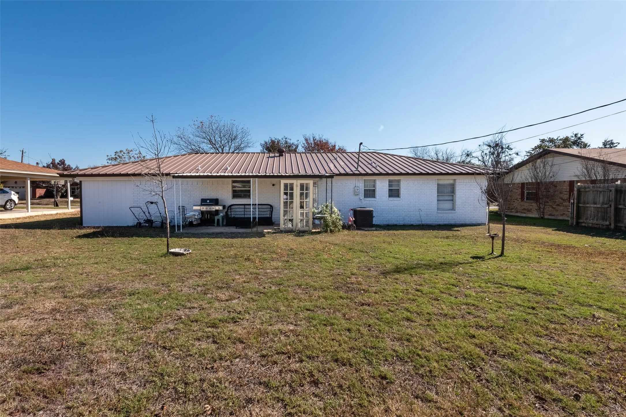 Rear view of house with a lawn and cooling unit