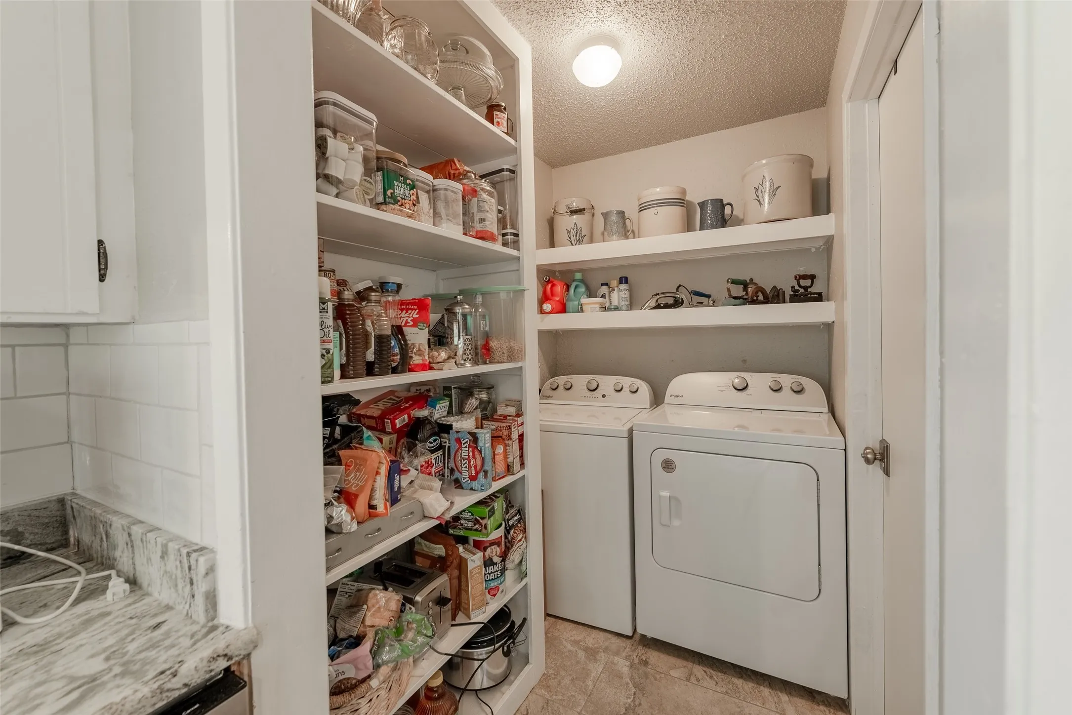 Washroom featuring a textured ceiling and washing machine and dryer
