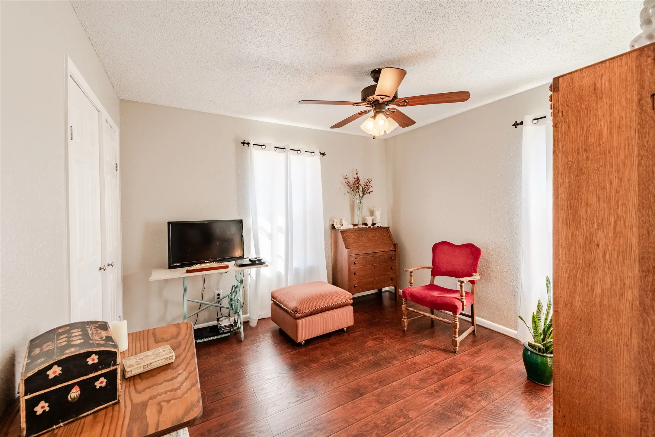 Living area featuring a textured ceiling, dark hardwood / wood-style flooring, and ceiling fan