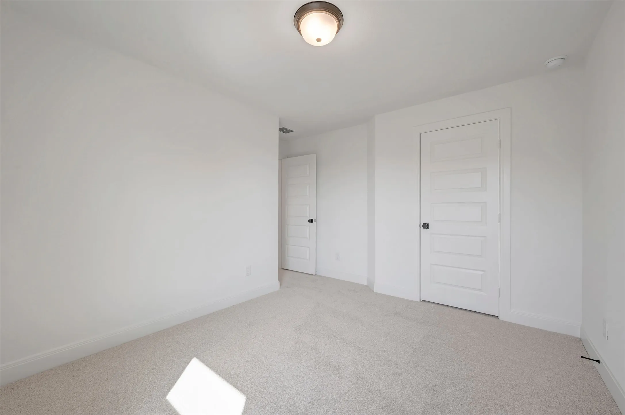 Neutral tone carpet flooring, white walls, and white trim create a bright interior