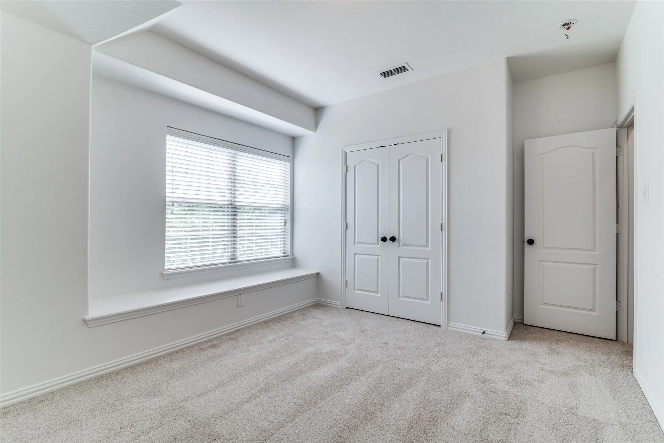 Upstairs bedroom #3 featuring light colored carpet and a closet