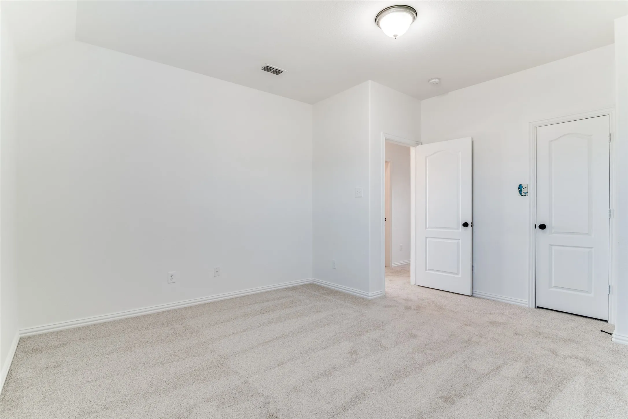 Upstairs bedroom #4 featuring light colored carpet and baseboards with a walk-in closet