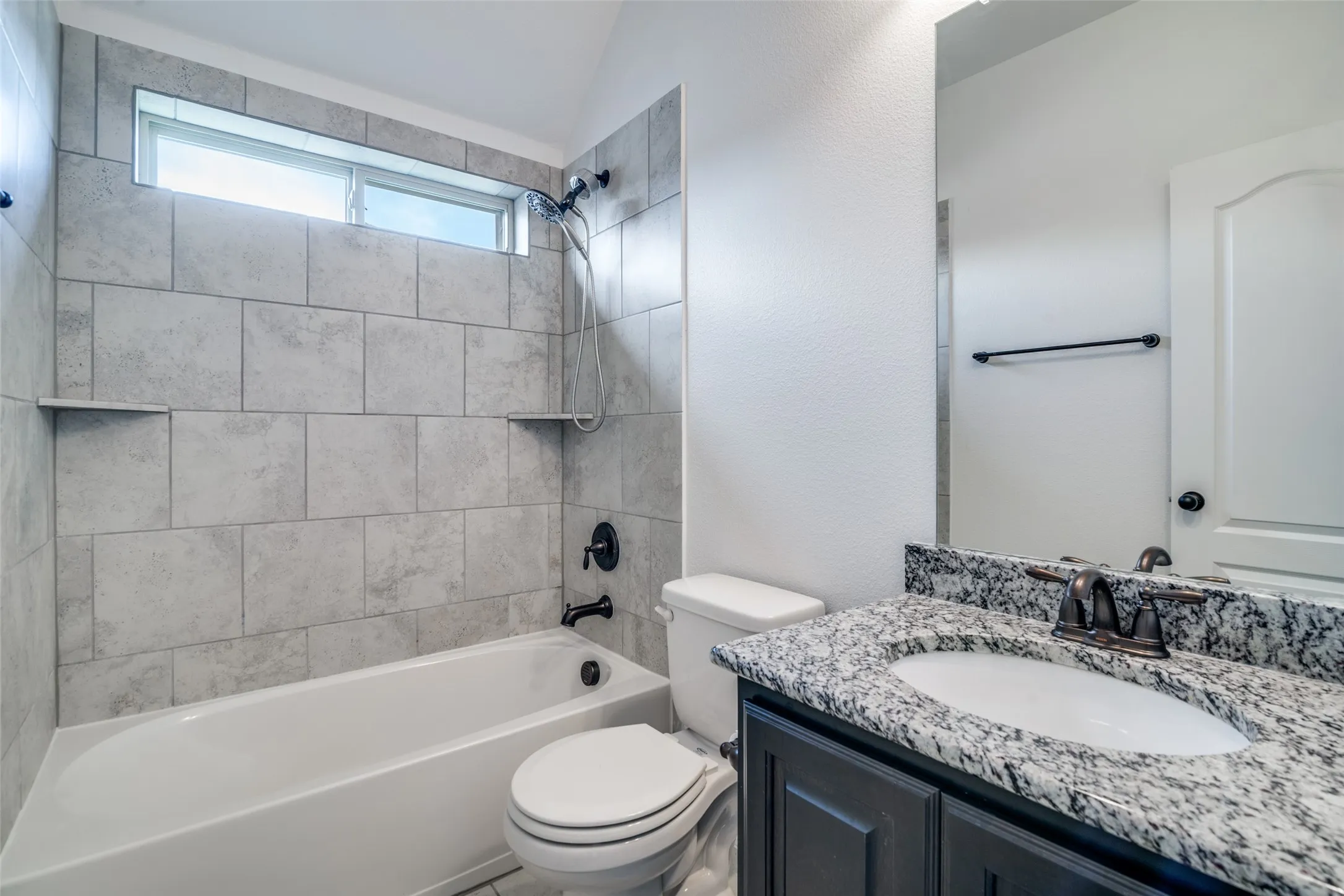 Ensuite bathroom for upstairs bedroom #2 featuring vanity, vaulted ceiling, and shower / washtub combination