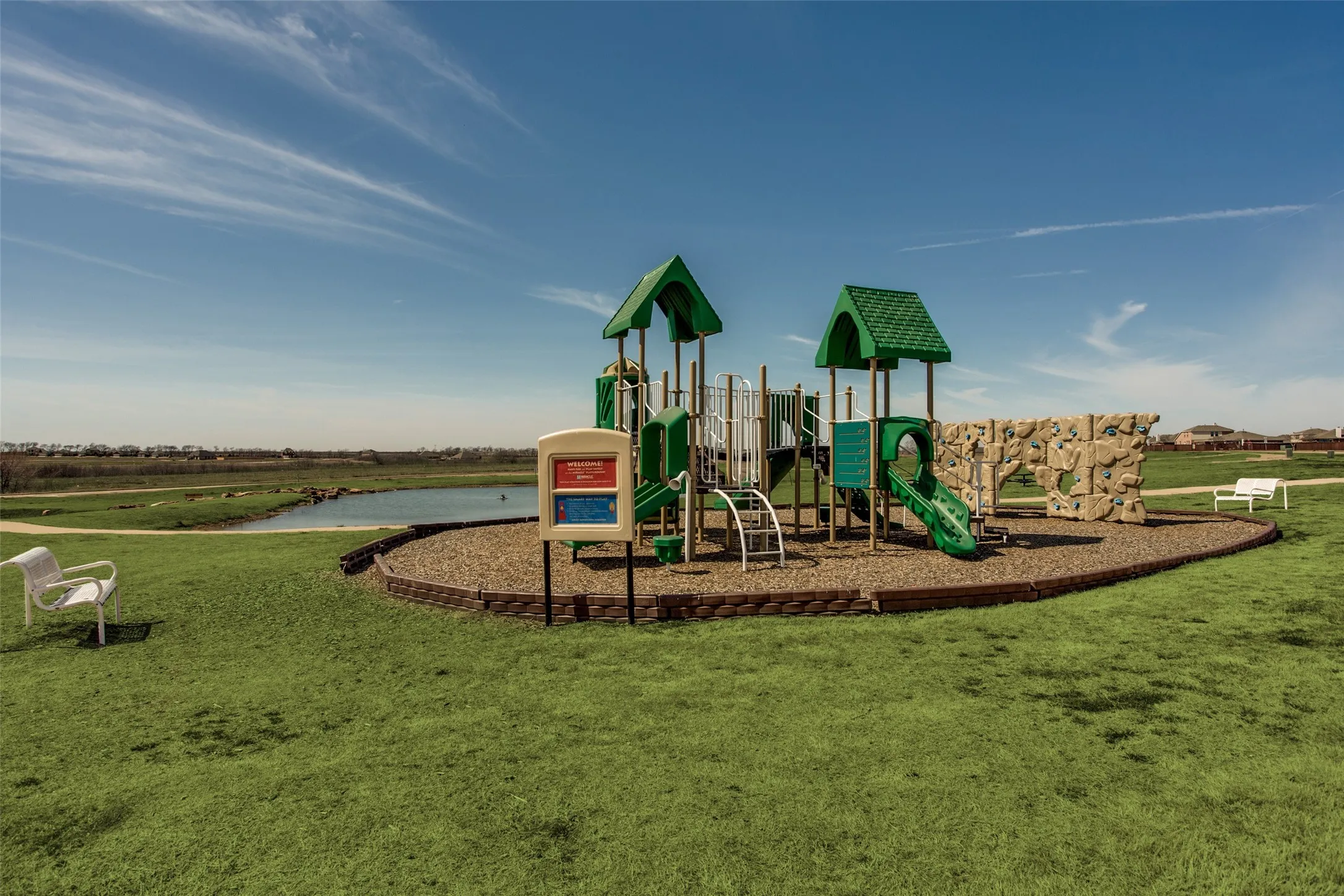 Recreational playground structure featuring multiple slides, climbing elements, and a rock wall