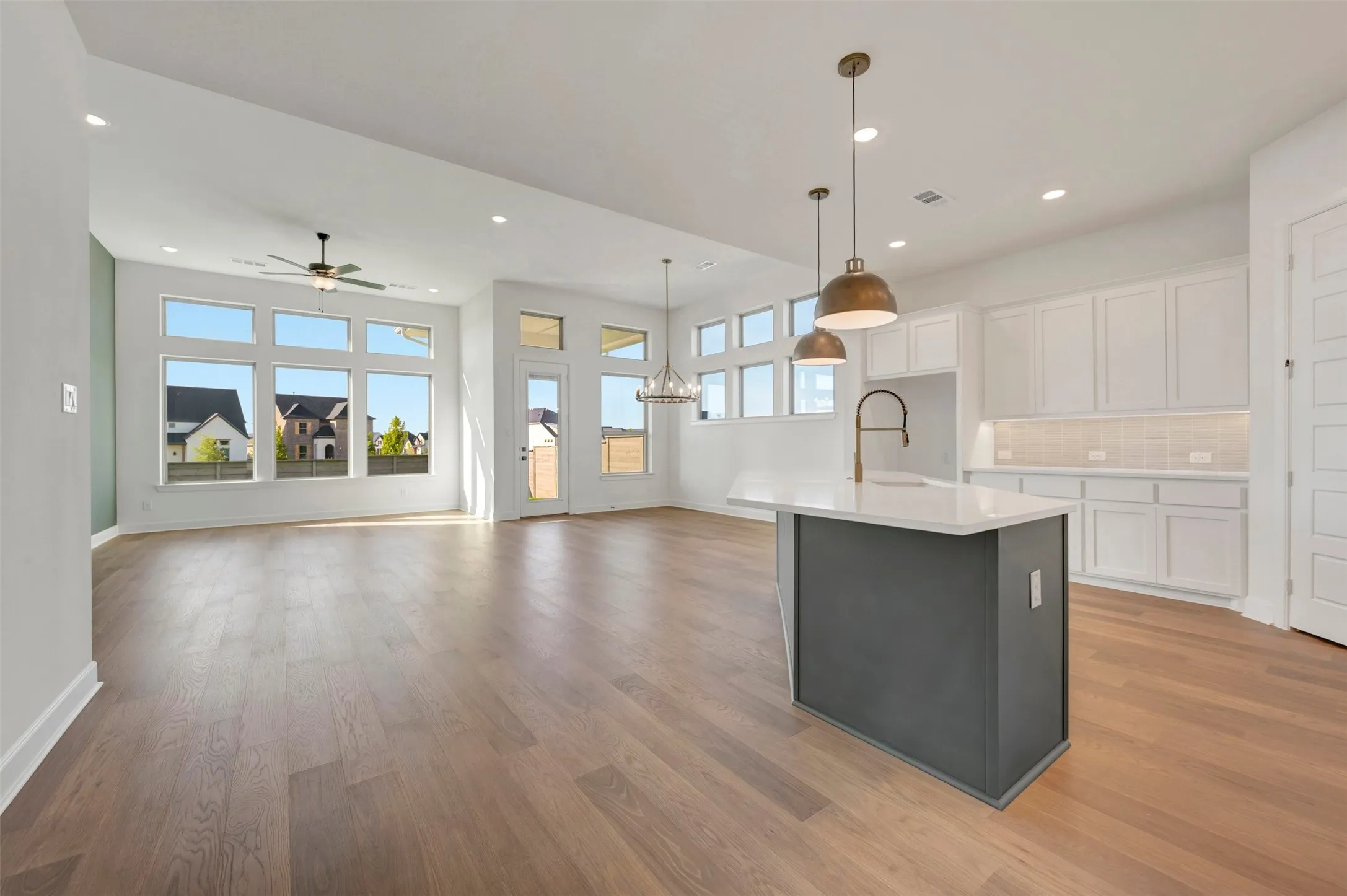 Open-concept living area featuring wood-finish flooring, recessed lighting, and a contemporary ceiling fan
