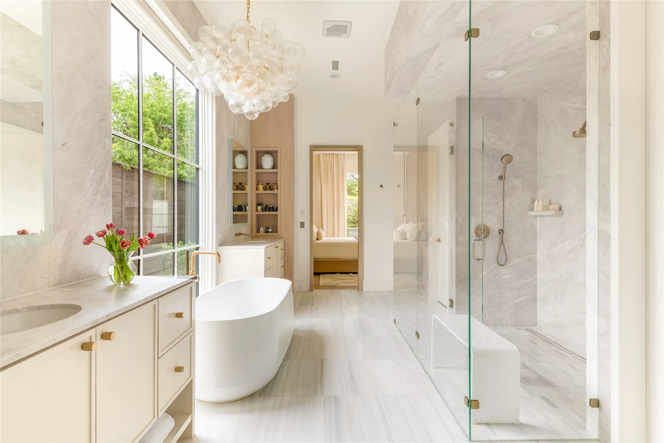 Primary Bathroom with dual water closets, oversized marble shower, and free standing garden tub