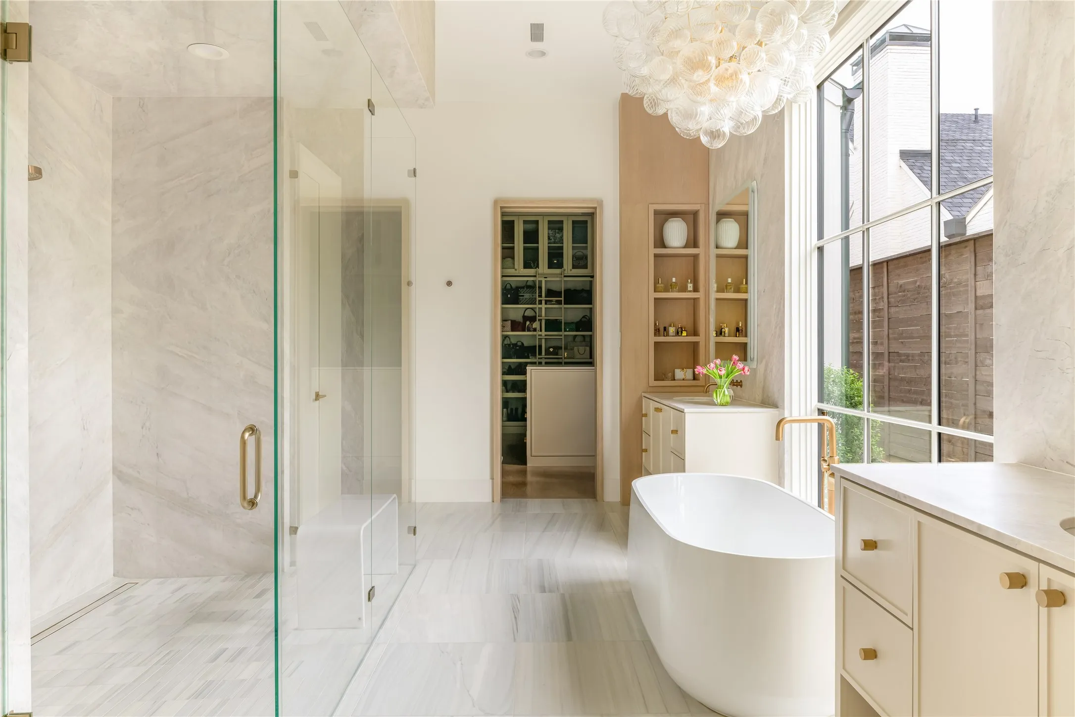 Primary Bathroom with dual water closets, oversized marble shower, and free standing garden tub