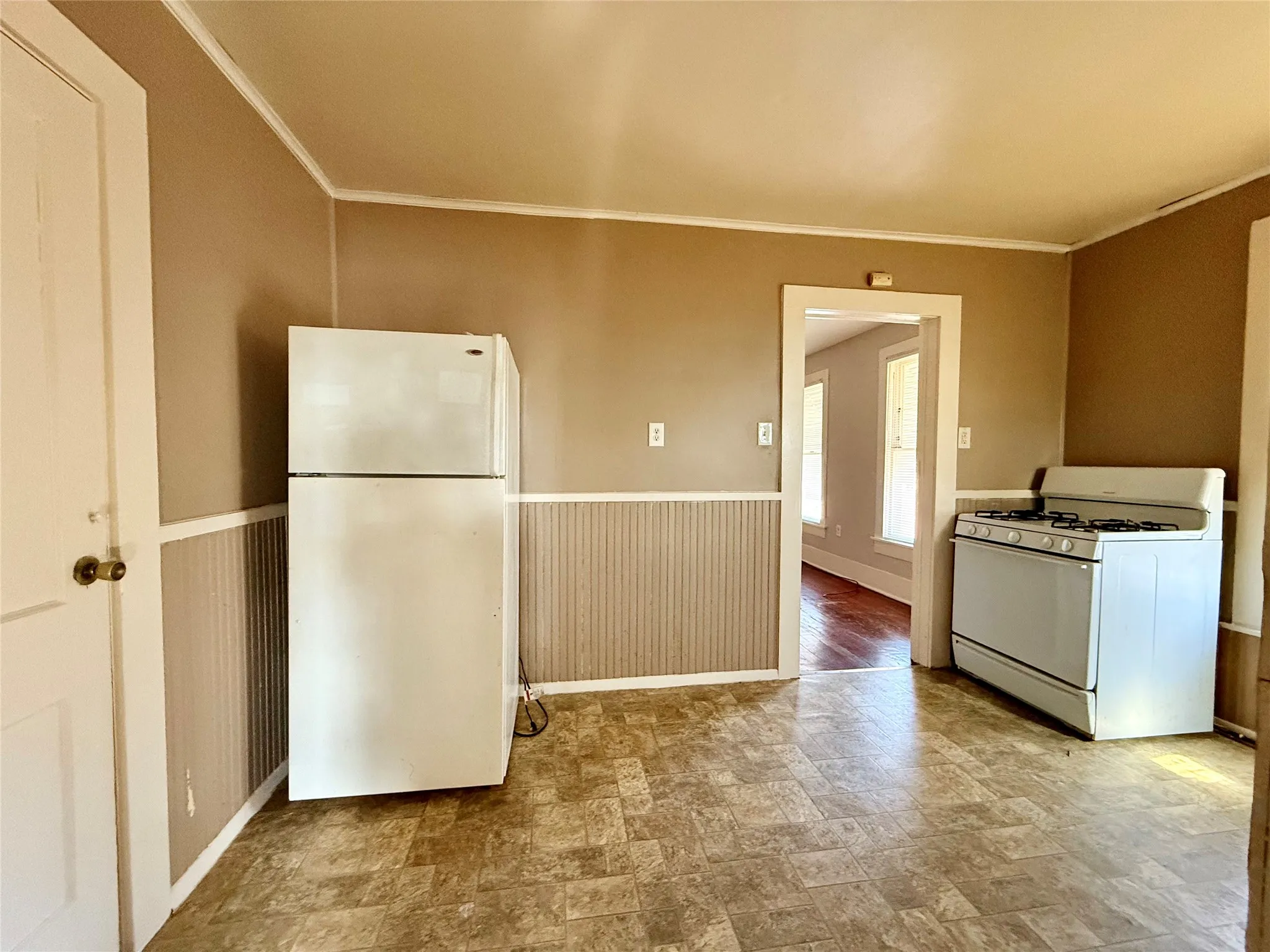 Kitchen featuring crown molding and white appliances