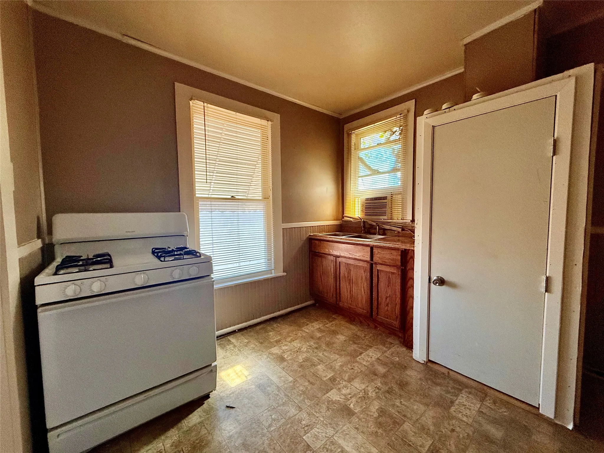 Kitchen with crown molding, plenty of natural light, sink, and gas range gas stove