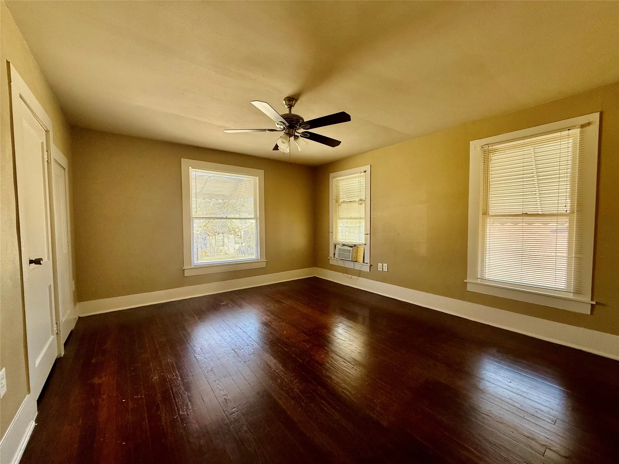 Unfurnished bedroom with cooling unit, ceiling fan, and hardwood / wood-style floors