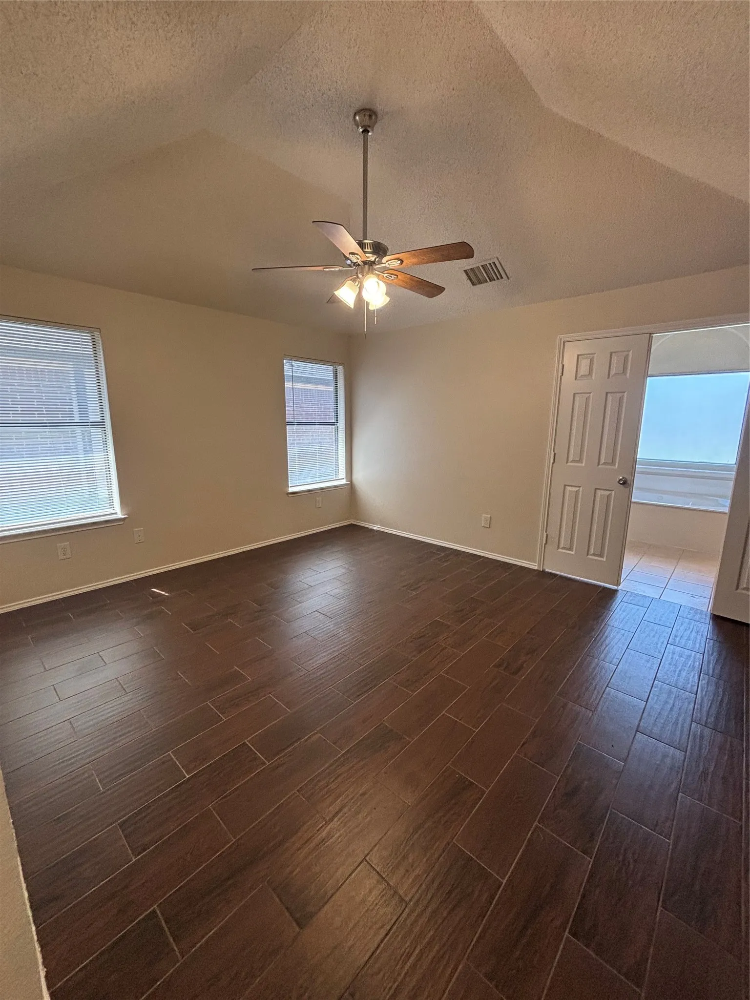 Spare room with wood finish floors and ceiling fan