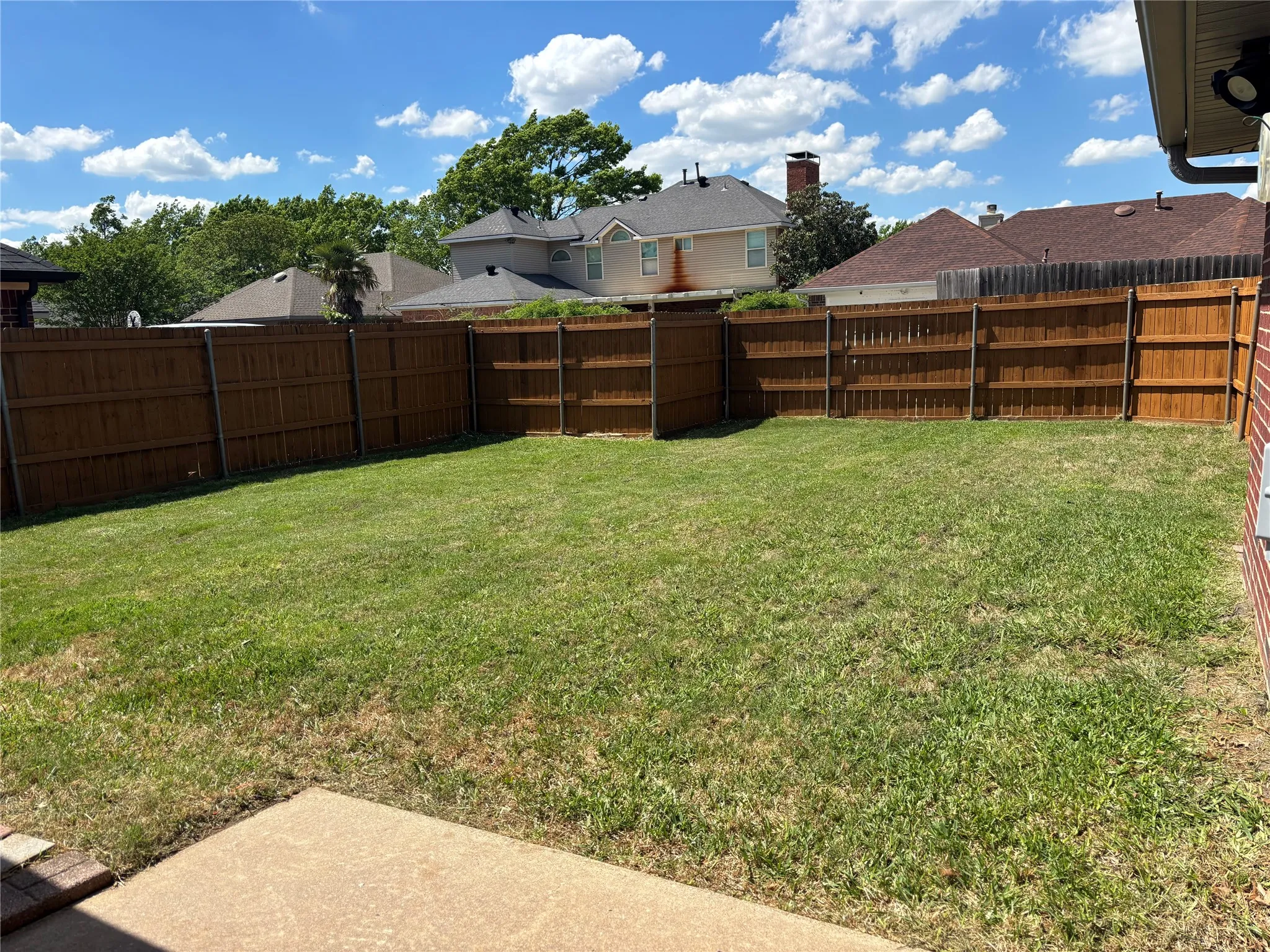 Fenced backyard with a residential view
