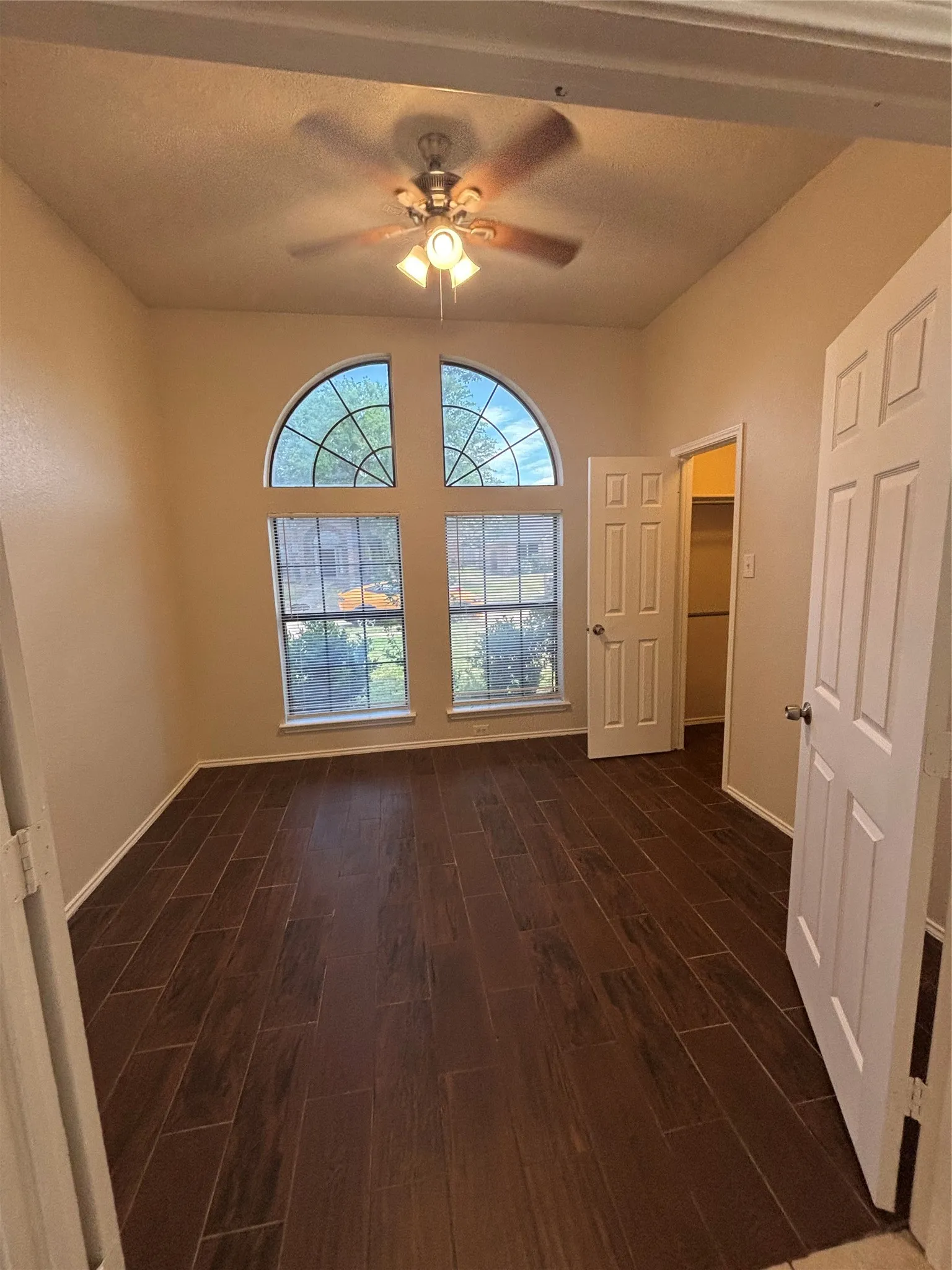 Unfurnished room with ceiling fan and dark wood finished floors