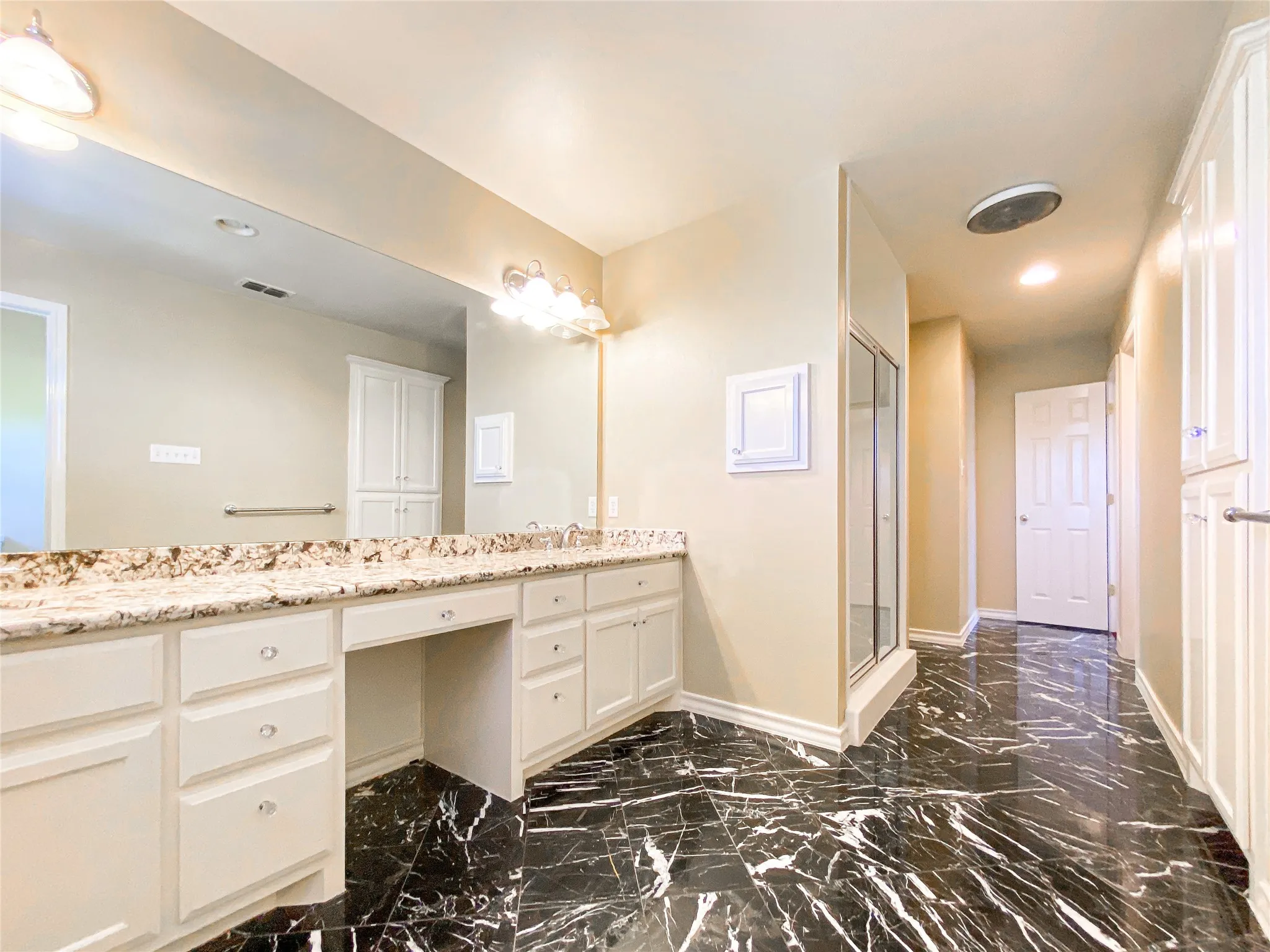 Full bath featuring double vanity, a shower stall, dark marble finish flooring, and recessed lighting