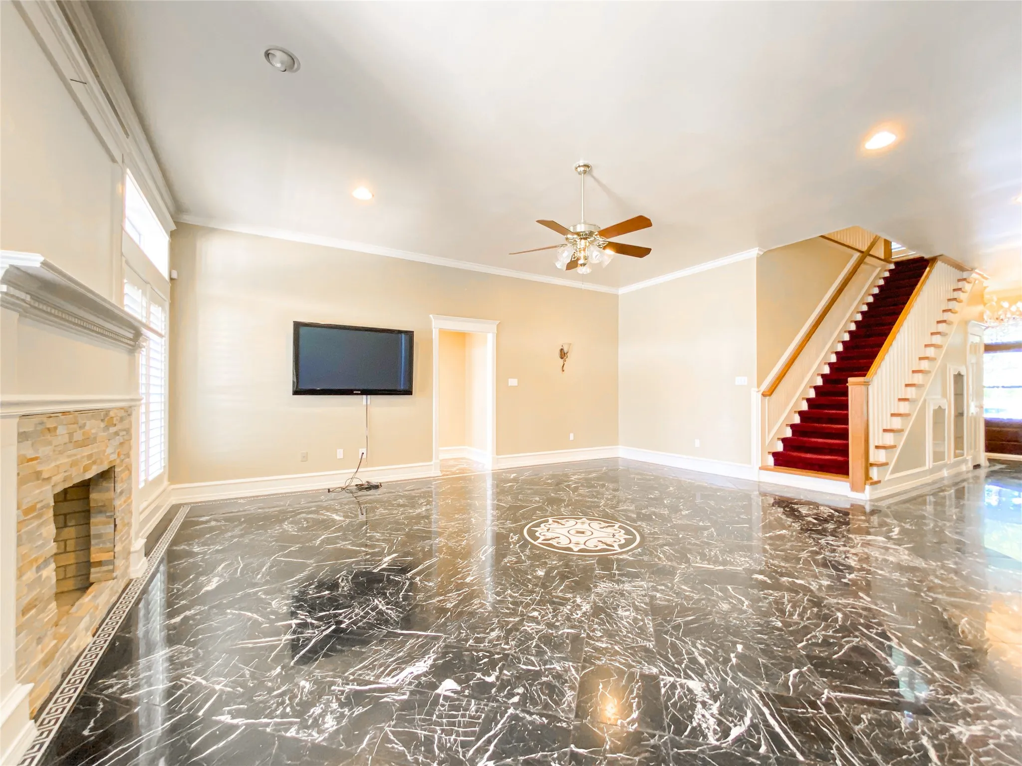 MAIN living room featuring marble tiled floors, ceiling fan, ornamental molding, and a fireplace