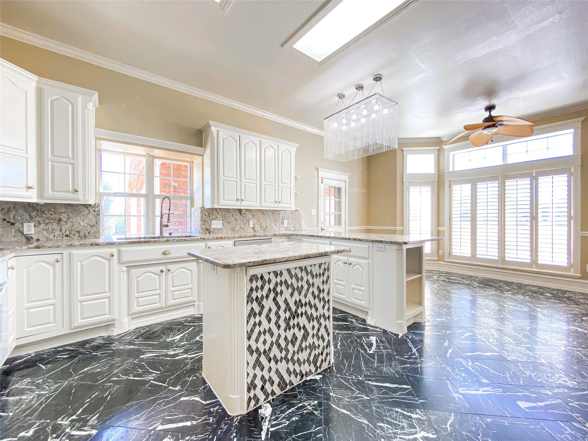 Kitchen with open shelves, a kitchen island, a peninsula, ceiling fan, and white cabinetry